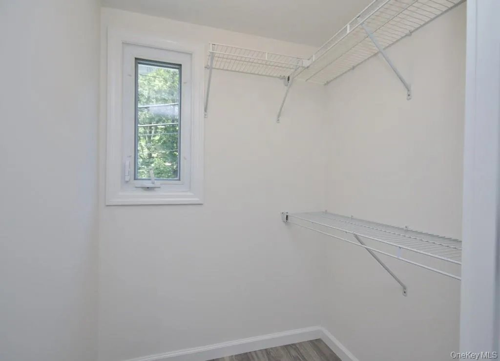 Walk in closet featuring light wood-type flooring Walk in closet featuring light wood-type flooring