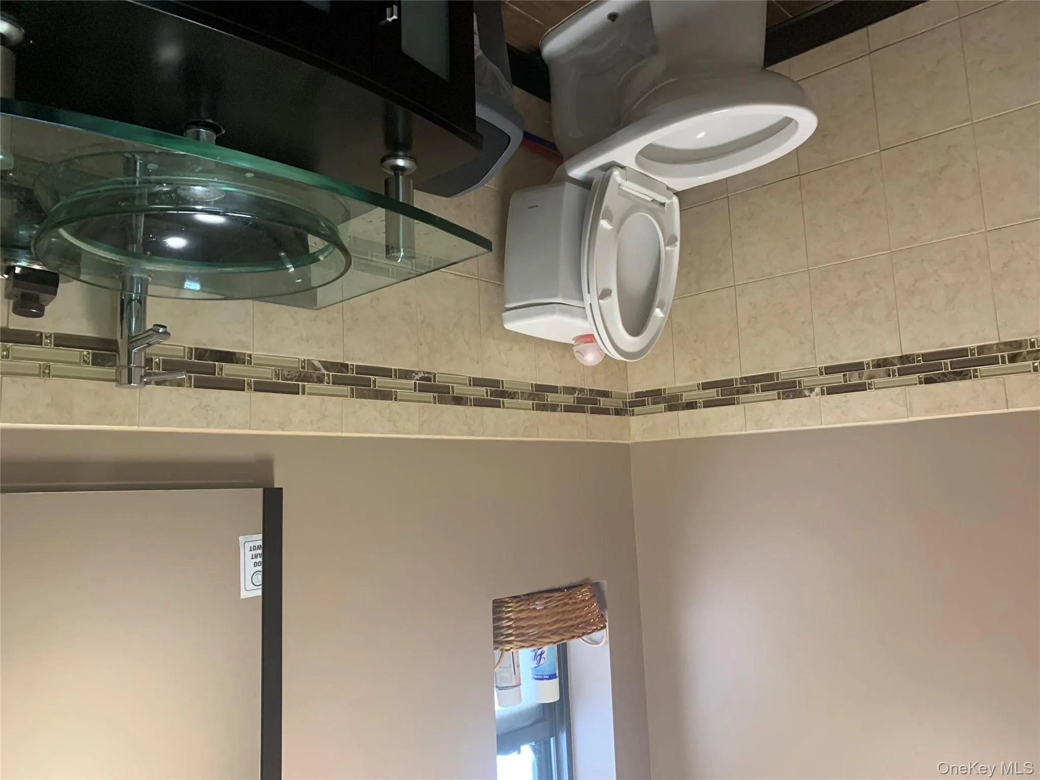 Half bath featuring tile walls, vanity, and wainscoting Half bath featuring tile walls, vanity, and wainscoting