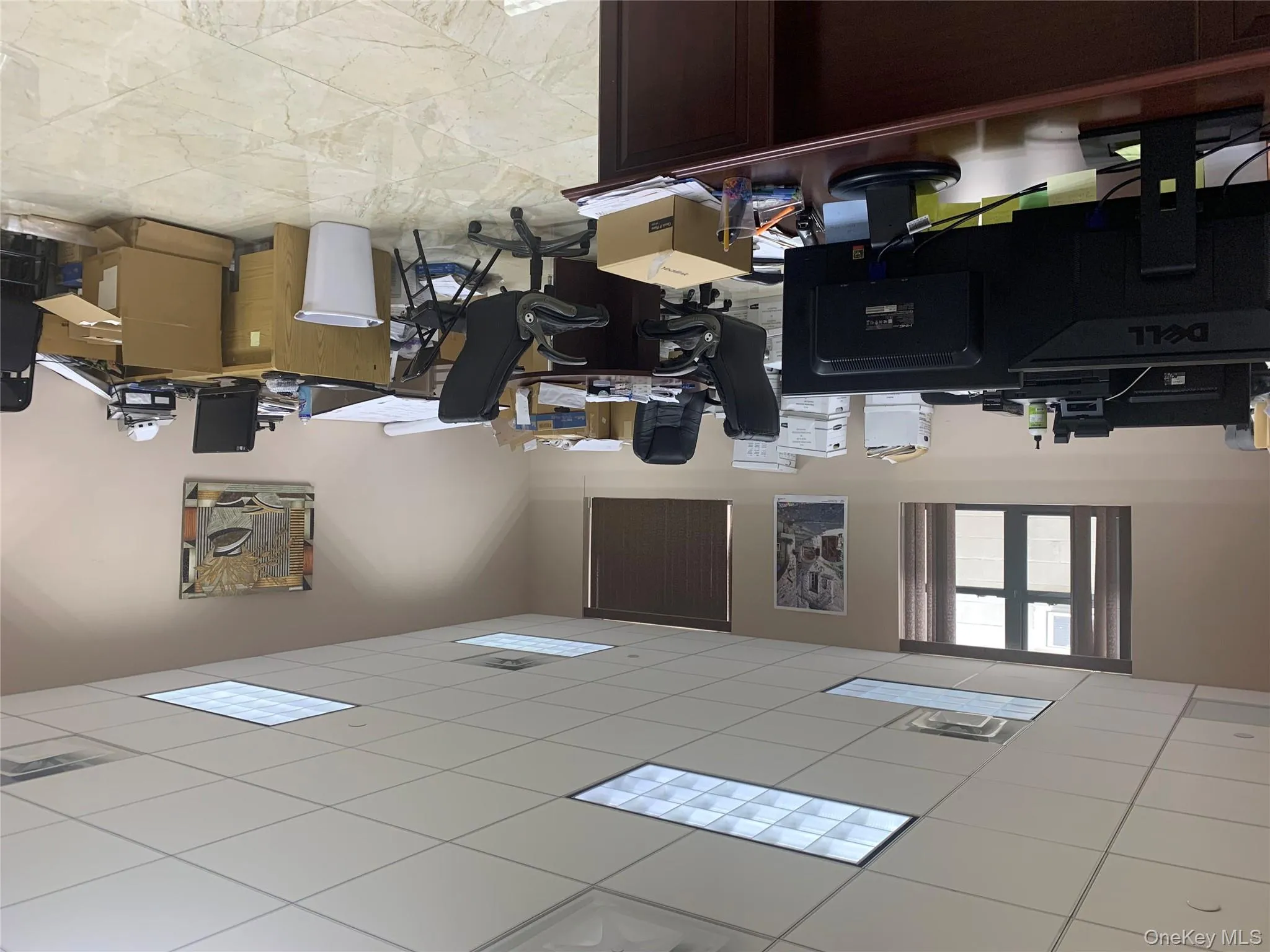 Office area with a drop ceiling and light marble finish flooring Office area with a drop ceiling and light marble finish flooring