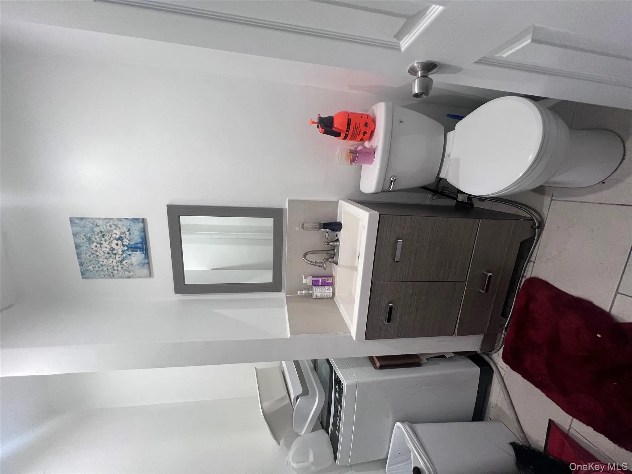 Half bathroom with vanity, light tile patterned flooring, and washer / clothes dryer Half bathroom with vanity, light tile patterned flooring, and washer / clothes dryer