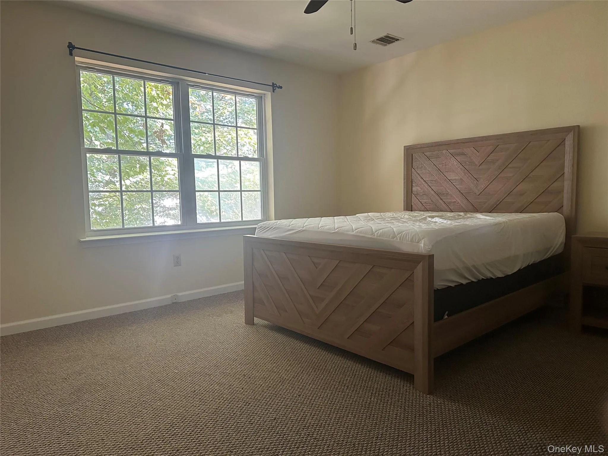 Carpeted bedroom featuring baseboards and a ceiling fan Carpeted bedroom featuring baseboards and a ceiling fan