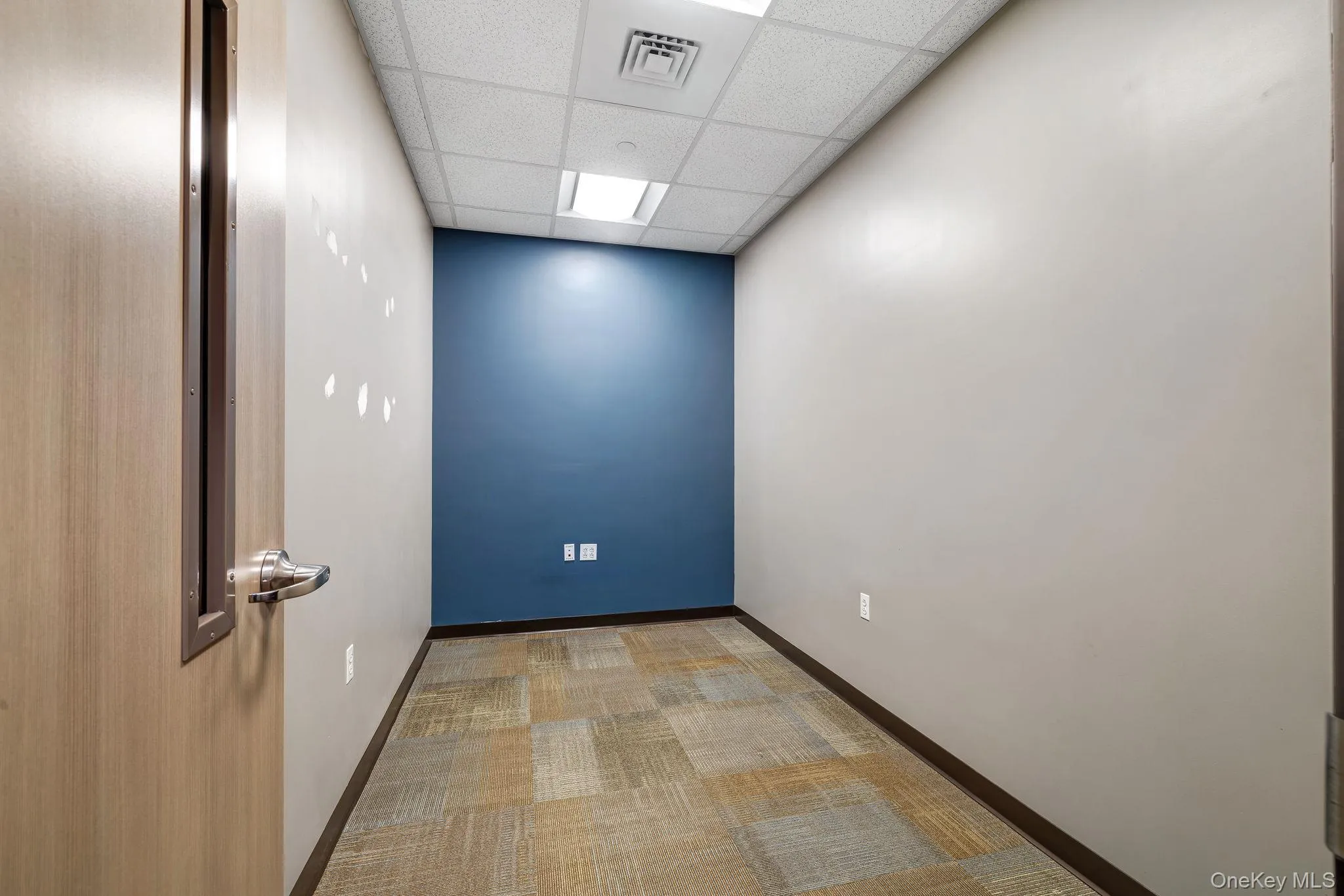 Empty room featuring a paneled ceiling and carpet Empty room featuring a paneled ceiling and carpet