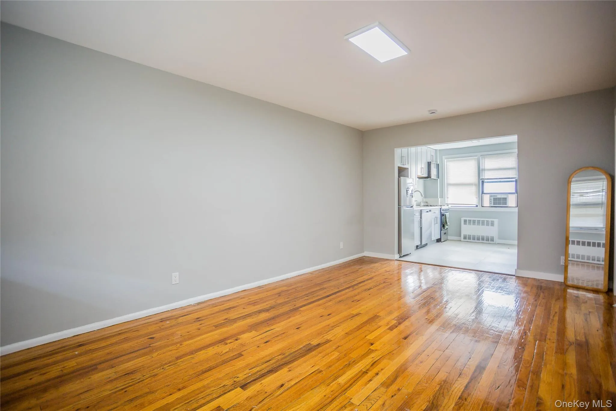 Unfurnished room with light wood-style floors and radiator heating unit Unfurnished room with light wood-style floors and radiator heating unit