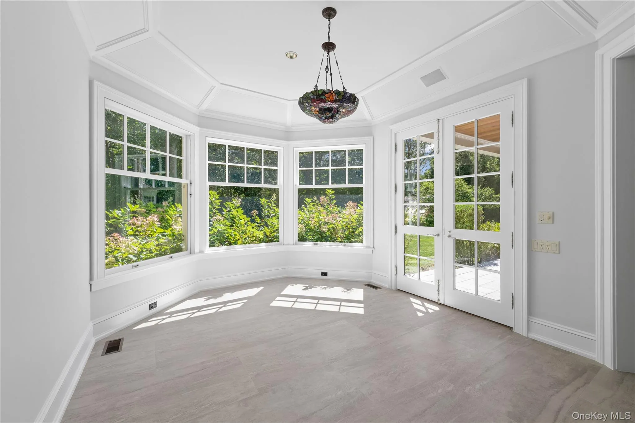 Unfurnished sunroom with healthy amount of natural light, french doors, and crown molding Unfurnished sunroom with healthy amount of natural light, french doors, and crown molding