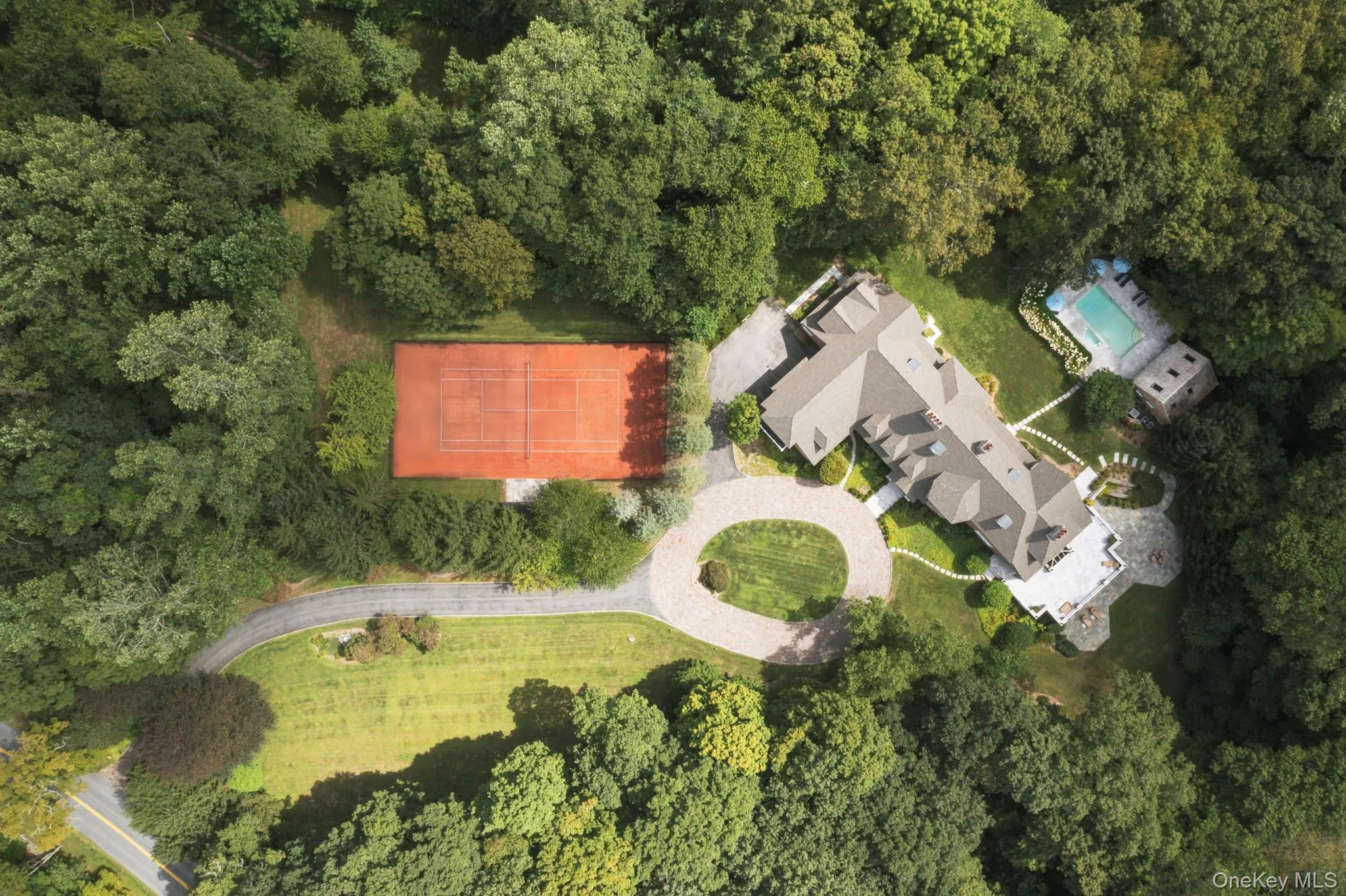 Aerial view of property's location with a forest Aerial view of property's location with a forest