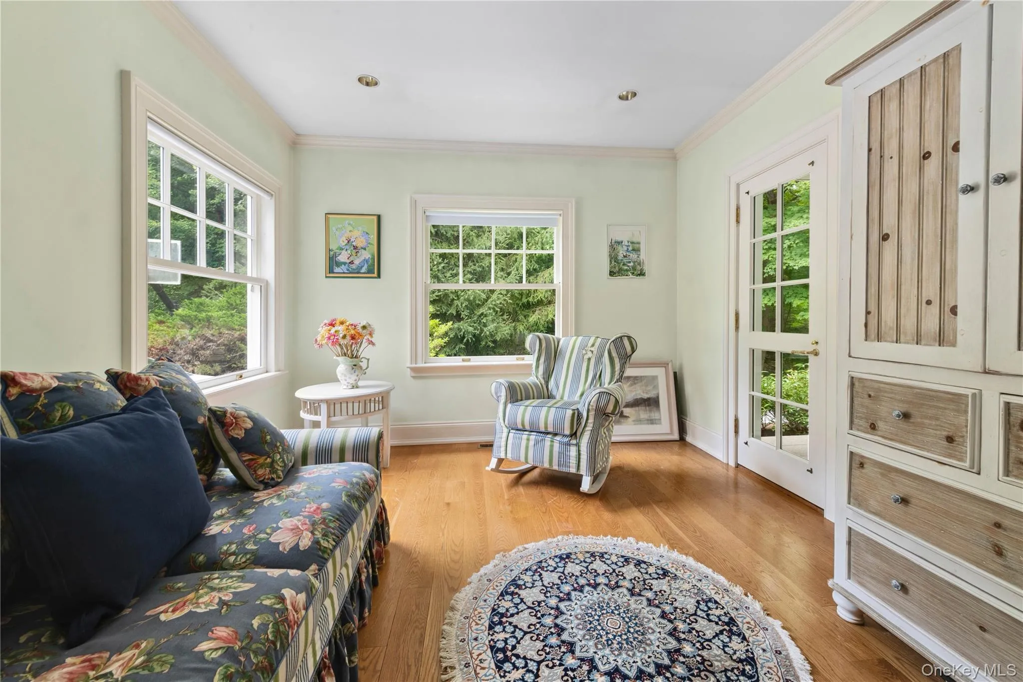 Living area with light wood-style floors and ornamental molding Living area with light wood-style floors and ornamental molding