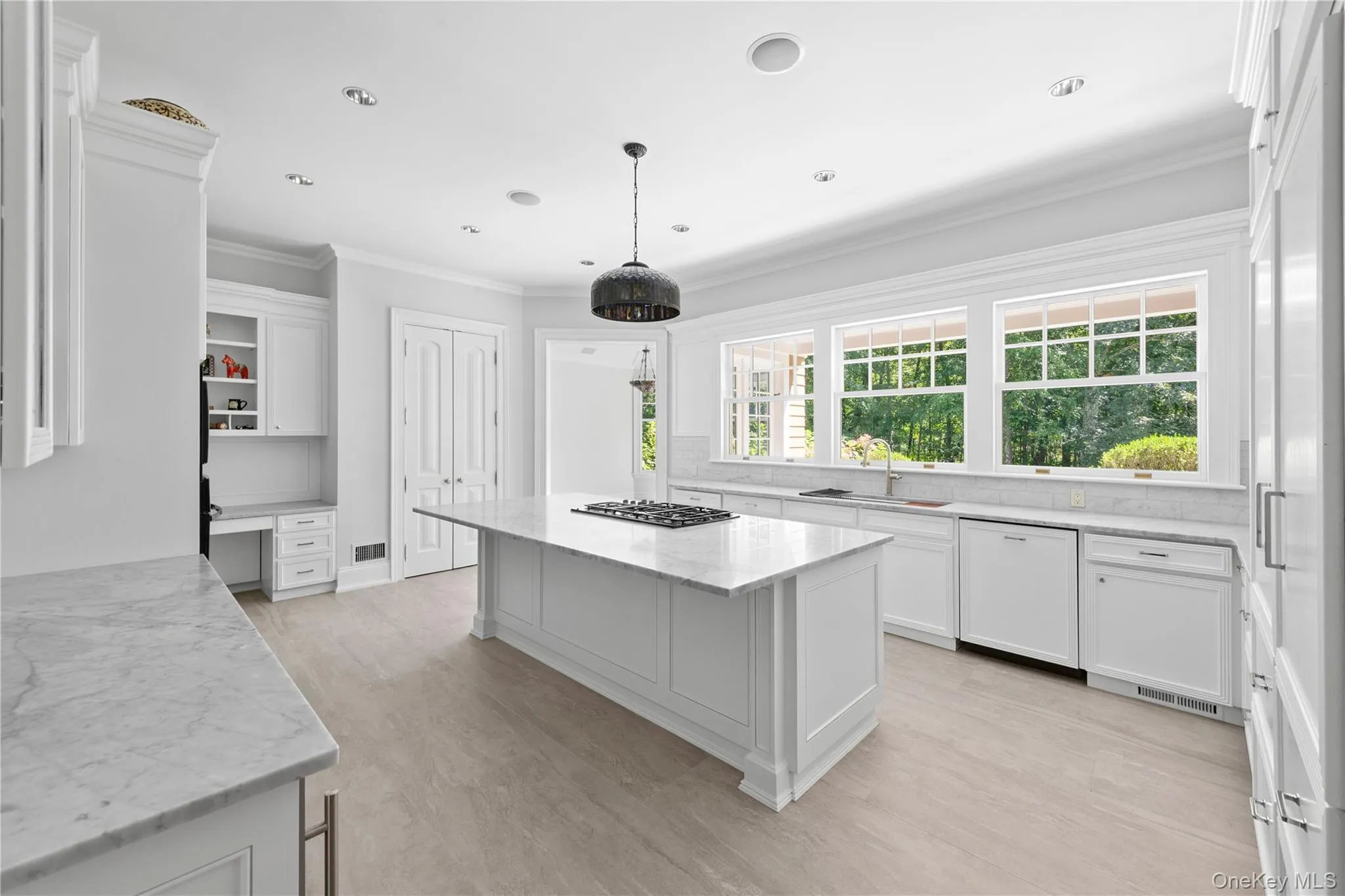 Kitchen with white cabinets, ornamental molding, light stone countertops, dishwasher, and decorative backsplash Kitchen with white cabinets, ornamental molding, light stone countertops, dishwasher, and decorative backsplash