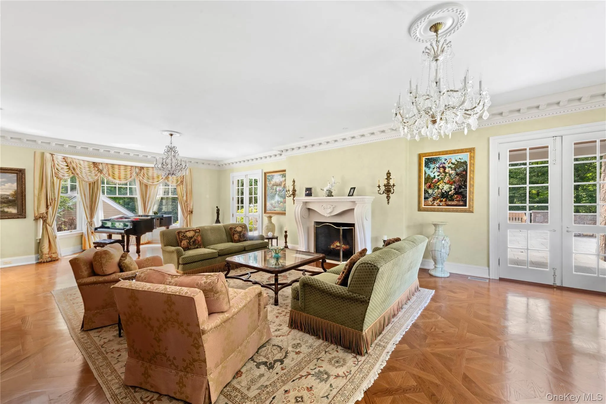 Living room featuring a chandelier, a warm lit fireplace, healthy amount of natural light, and french doors Living room featuring a chandelier, a warm lit fireplace, healthy amount of natural light, and french doors