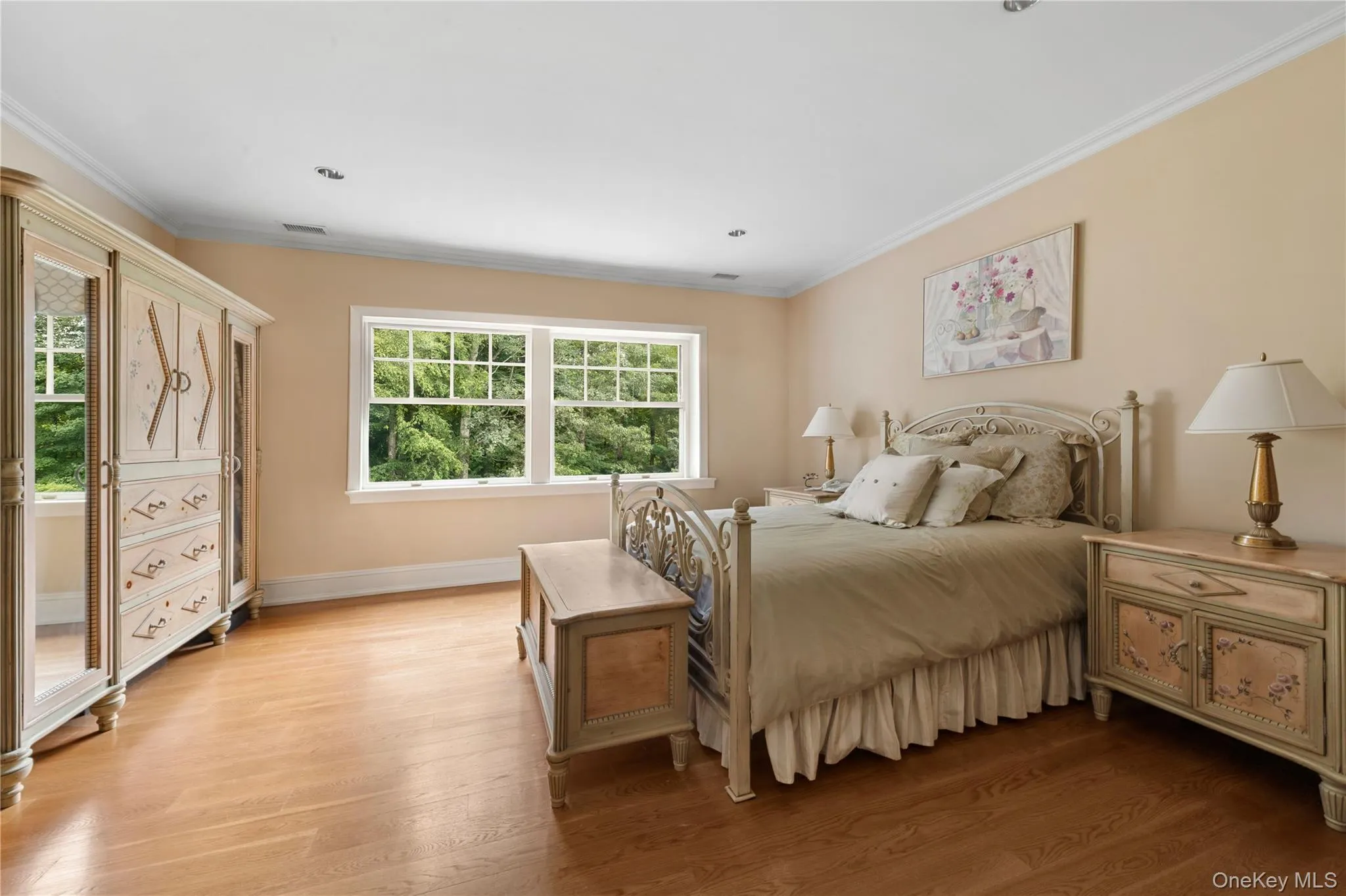 Bedroom with crown molding and light wood finished floors Bedroom with crown molding and light wood finished floors