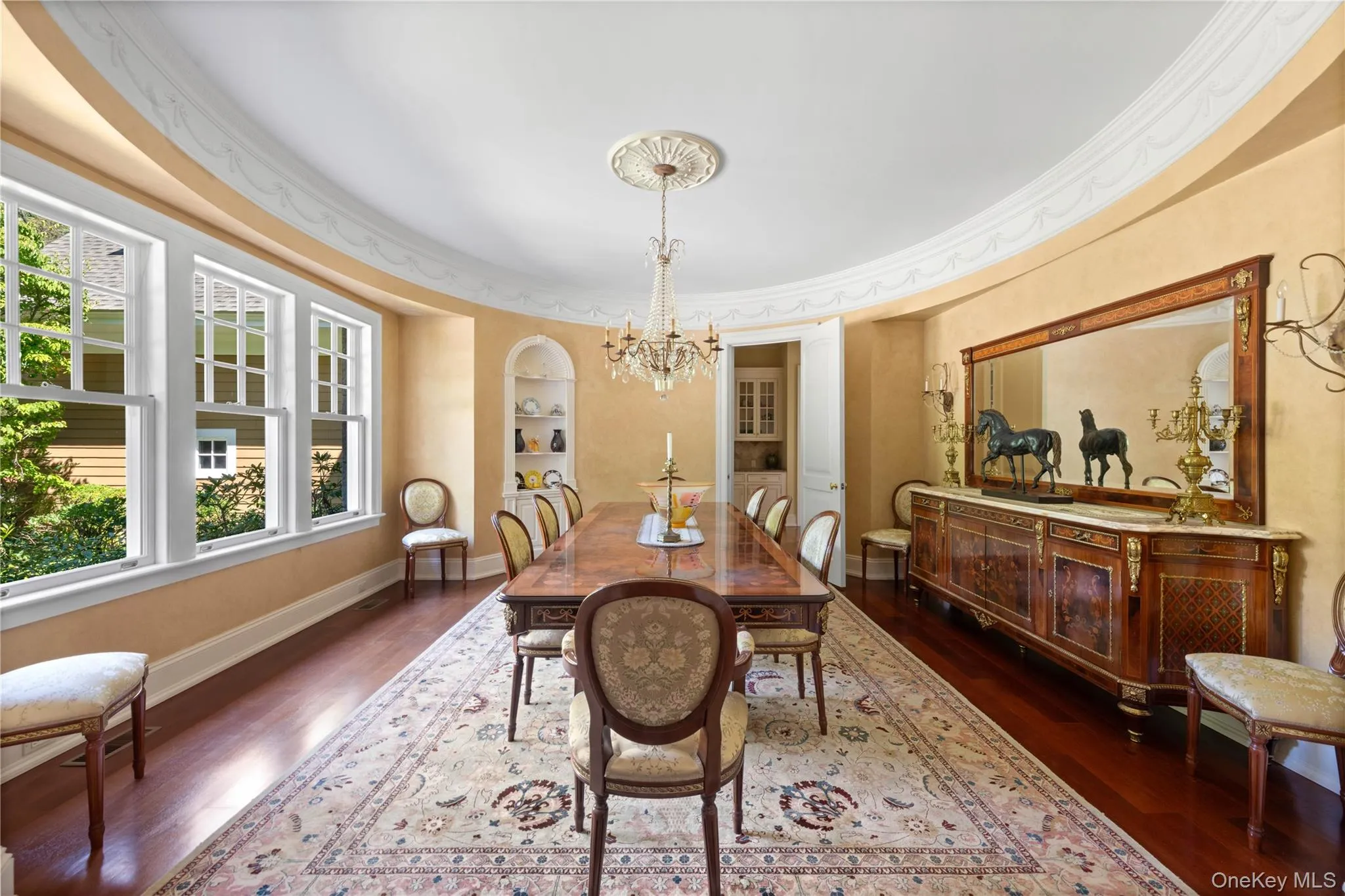 Dining room with dark wood finished floors, a chandelier, and built in shelves Dining room with dark wood finished floors, a chandelier, and built in shelves