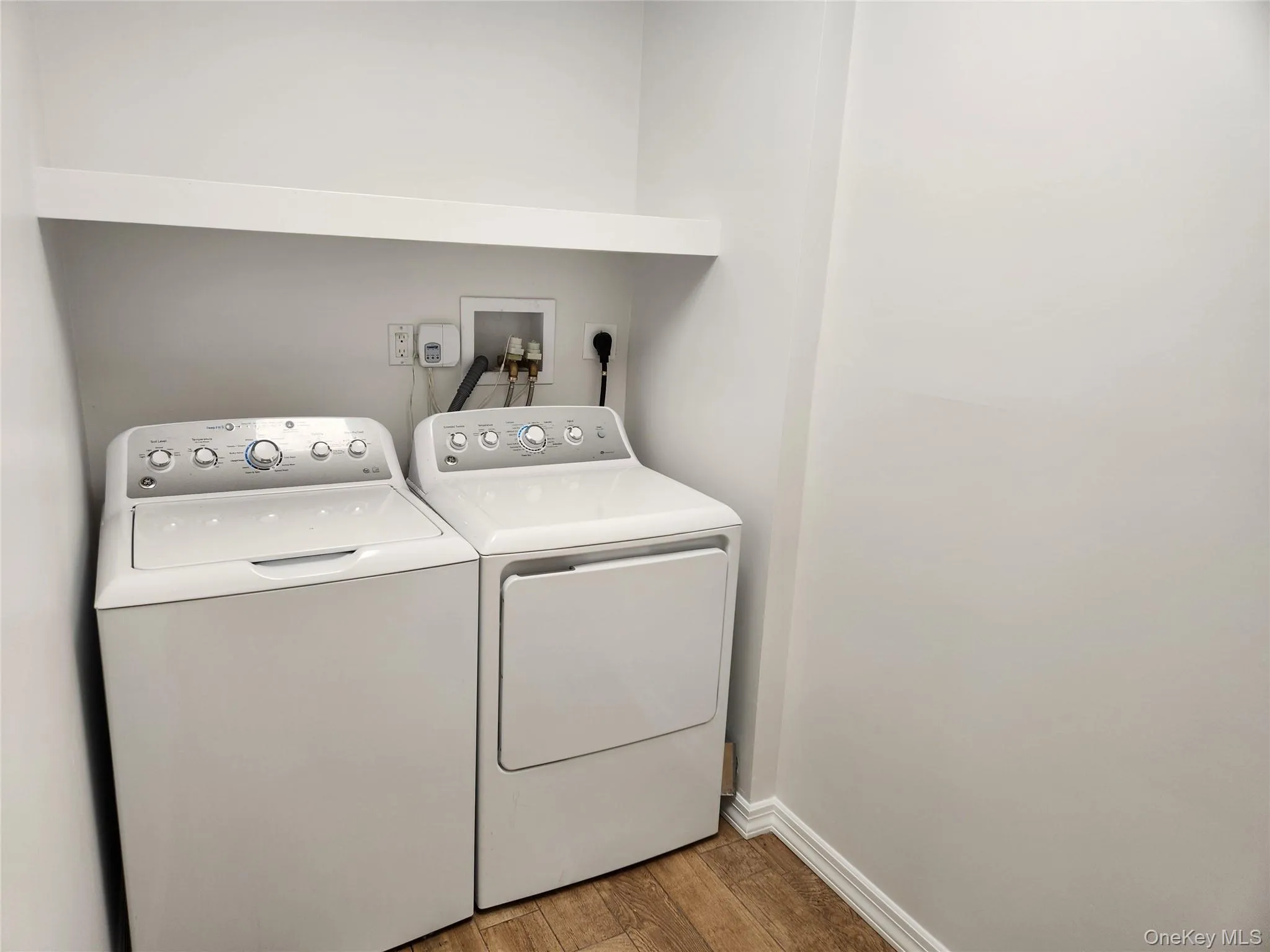 Laundry area featuring wood finished floors and independent washer and dryer Laundry area featuring wood finished floors and independent washer and dryer