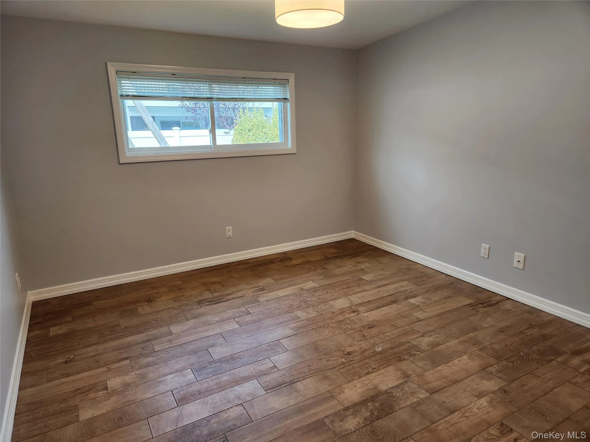Spare room featuring baseboards and wood finished floors Spare room featuring baseboards and wood finished floors