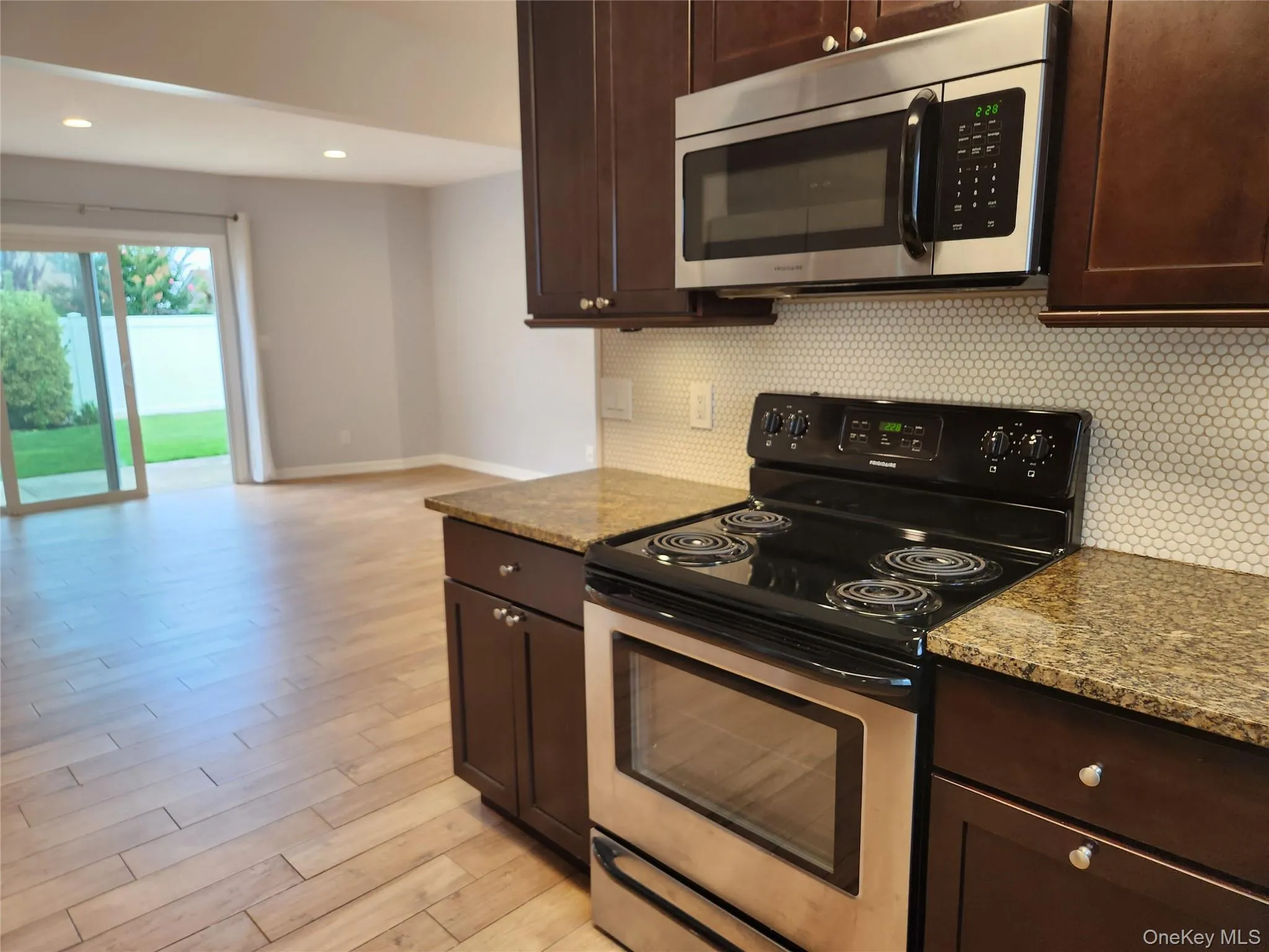 Kitchen featuring stainless steel appliances, dark brown cabinetry, decorative backsplash, and recessed lighting Kitchen featuring stainless steel appliances, dark brown cabinetry, decorative backsplash, and recessed lighting