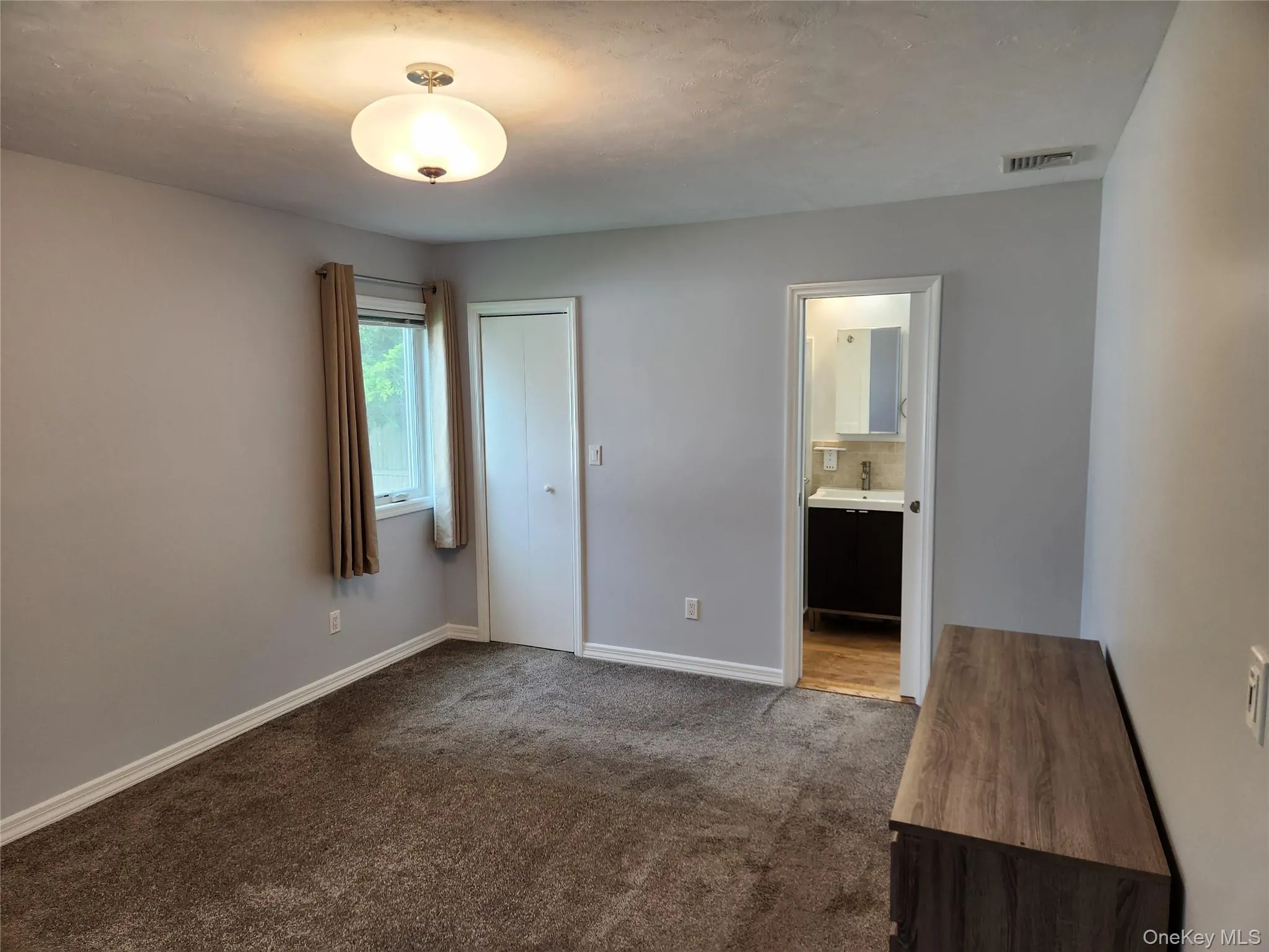 Unfurnished bedroom with dark carpet and a closet Unfurnished bedroom with dark carpet and a closet