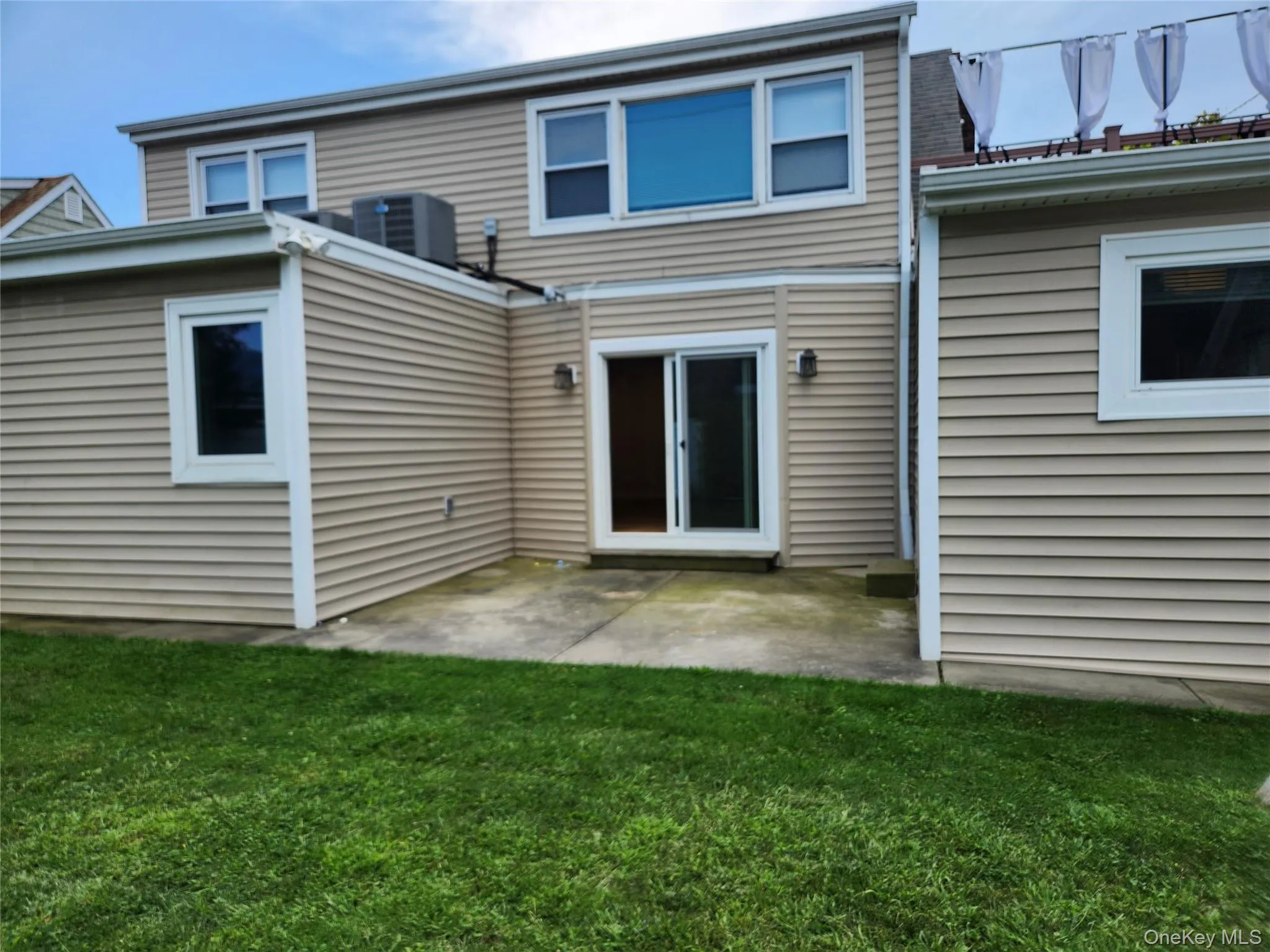 Back of house with a lawn and a patio area Back of house with a lawn and a patio area