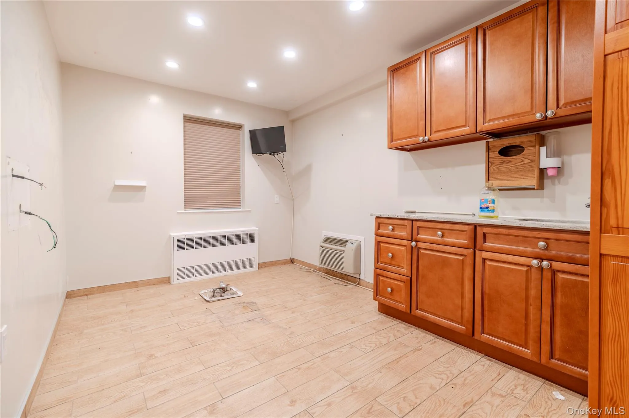 Washroom featuring radiator, recessed lighting, and light wood-type flooring Washroom featuring radiator, recessed lighting, and light wood-type flooring