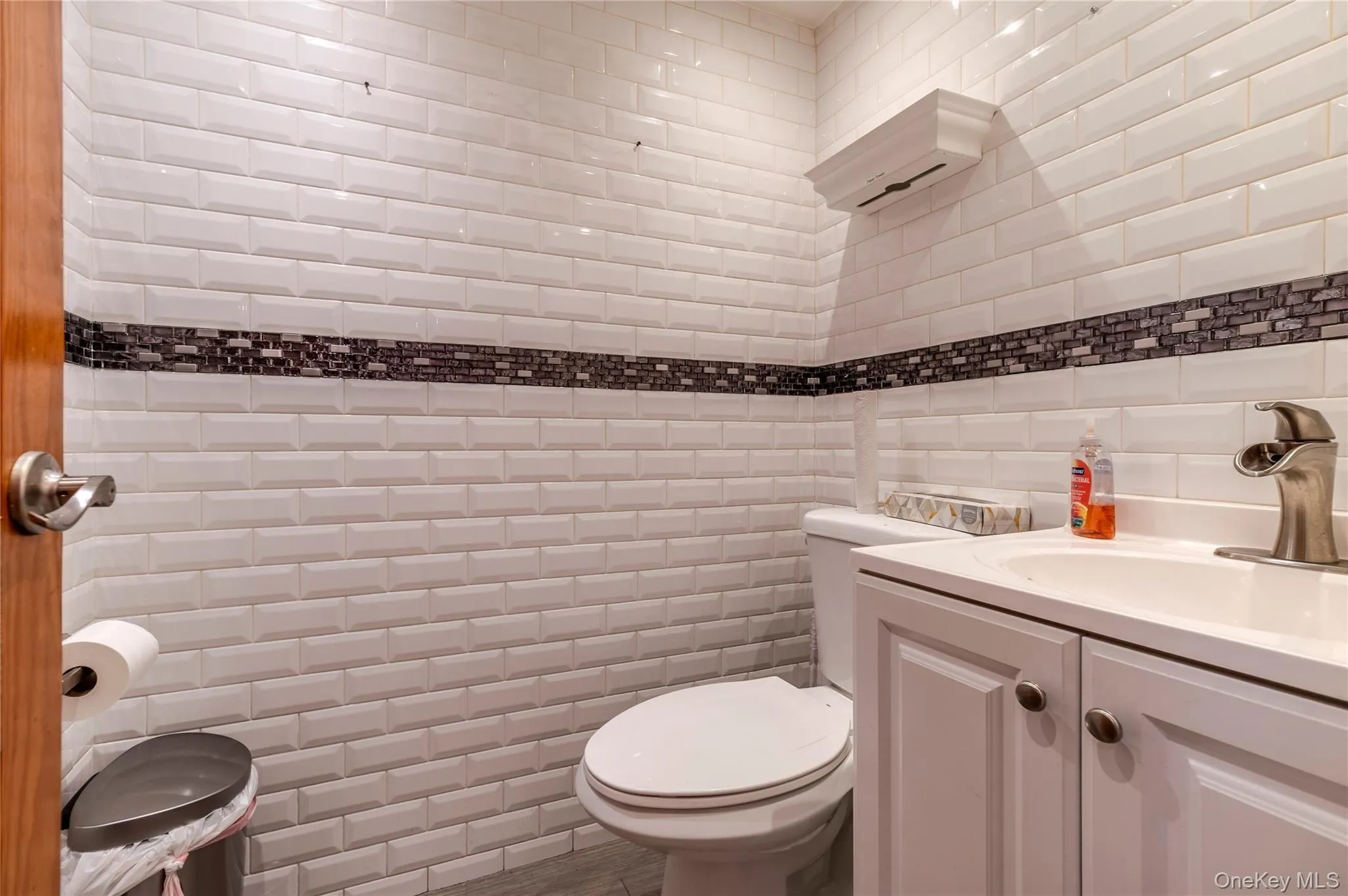 Half bath featuring vanity and tile walls Half bath featuring vanity and tile walls