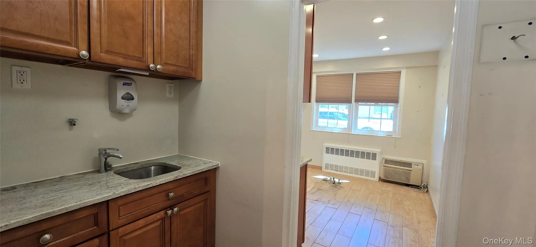 Laundry area featuring radiator heating unit, light wood-type flooring, and recessed lighting Laundry area featuring radiator heating unit, light wood-type flooring, and recessed lighting
