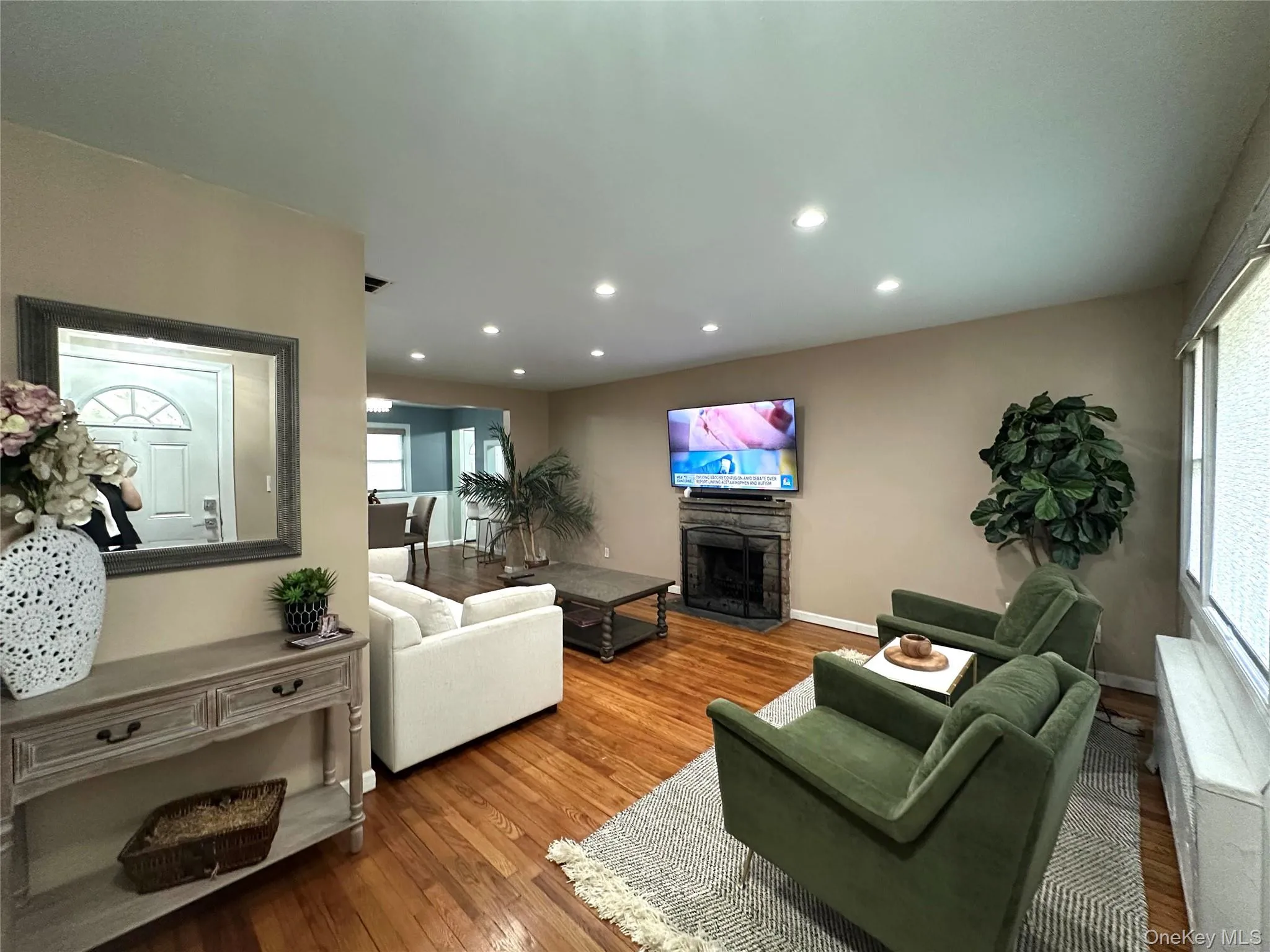Living area featuring a fireplace, wood finished floors, and recessed lighting Living area featuring a fireplace, wood finished floors, and recessed lighting