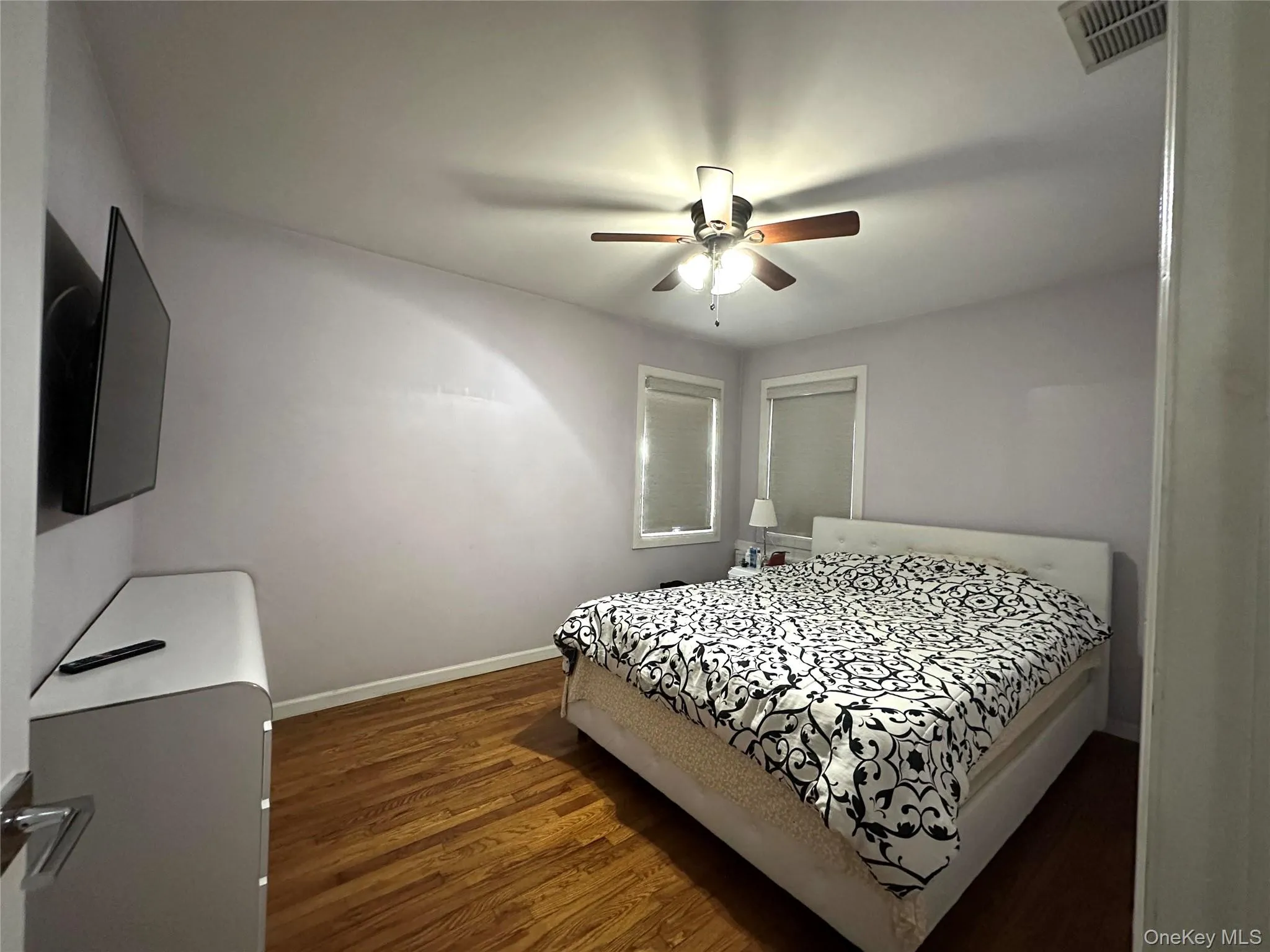 Bedroom featuring dark wood-style flooring and a ceiling fan Bedroom featuring dark wood-style flooring and a ceiling fan