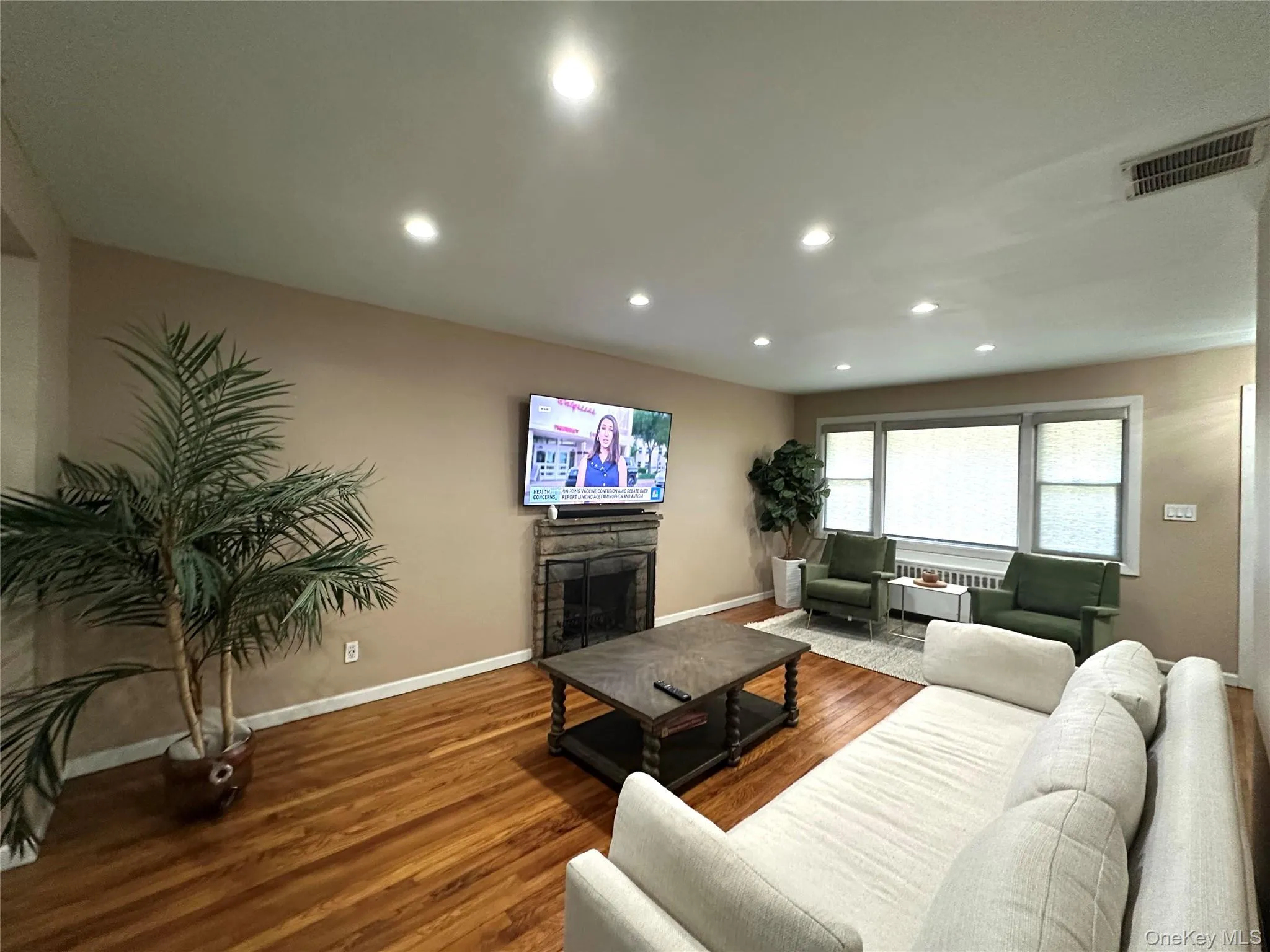Living area with wood finished floors, a fireplace, and recessed lighting Living area with wood finished floors, a fireplace, and recessed lighting