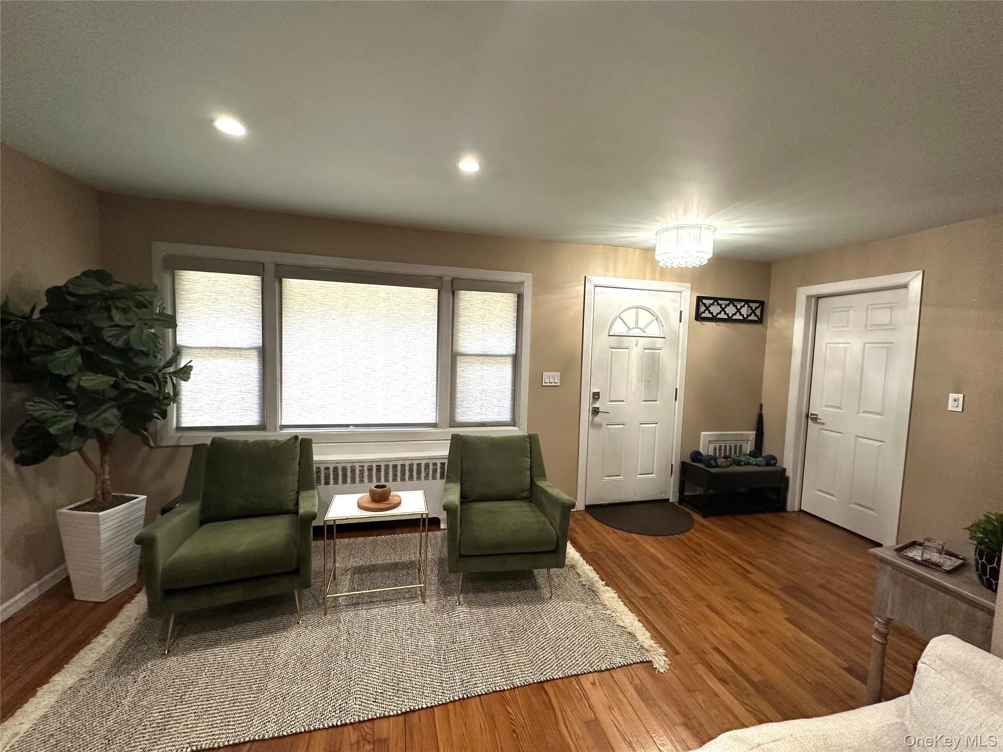 Living area with wood finished floors, radiator heating unit, and recessed lighting Living area with wood finished floors, radiator heating unit, and recessed lighting