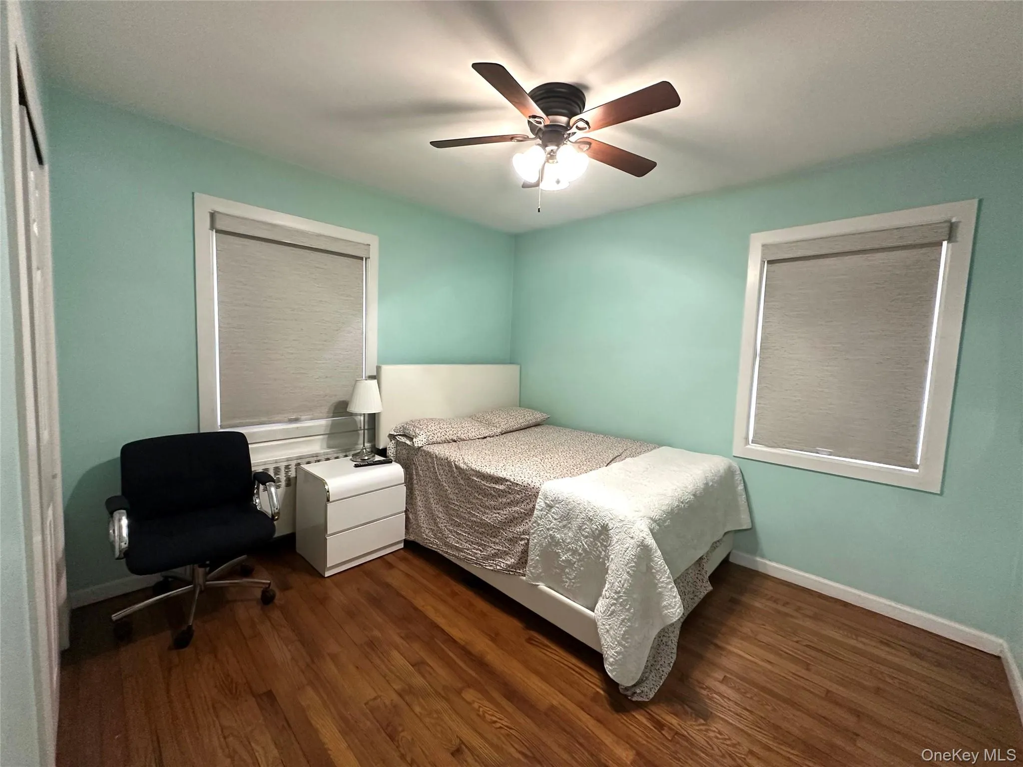 Bedroom with dark wood finished floors and a ceiling fan Bedroom with dark wood finished floors and a ceiling fan