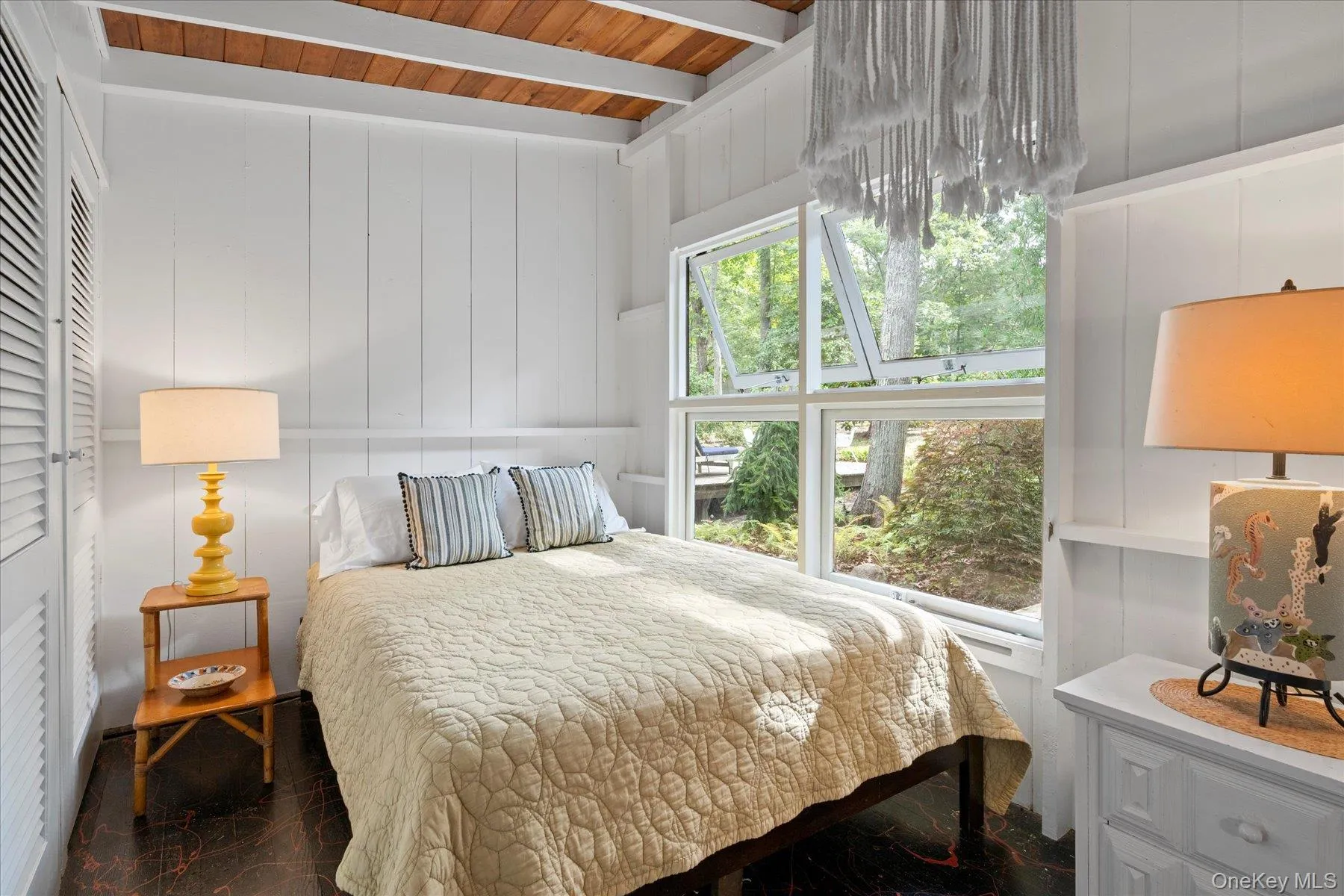 Bedroom featuring wood walls and a wood ceiling with exposed beams