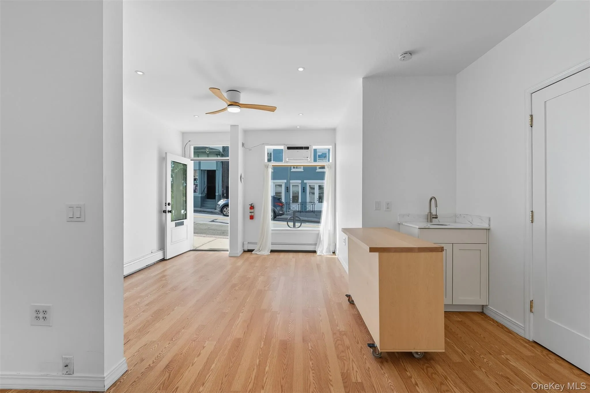 Bar with light wood-style flooring, wooden counters, and ceiling fan Bar with light wood-style flooring, wooden counters, and ceiling fan