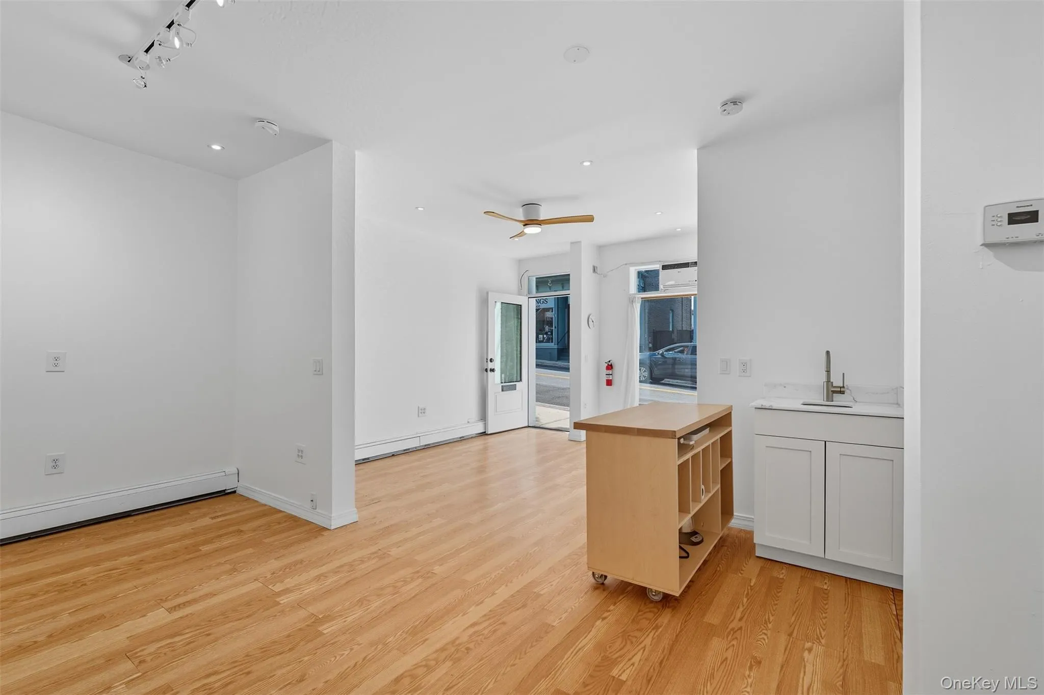 Kitchen with light wood-type flooring, a ceiling fan, butcher block countertops, open floor plan, and rail lighting Kitchen with light wood-type flooring, a ceiling fan, butcher block countertops, open floor plan, and rail lighting