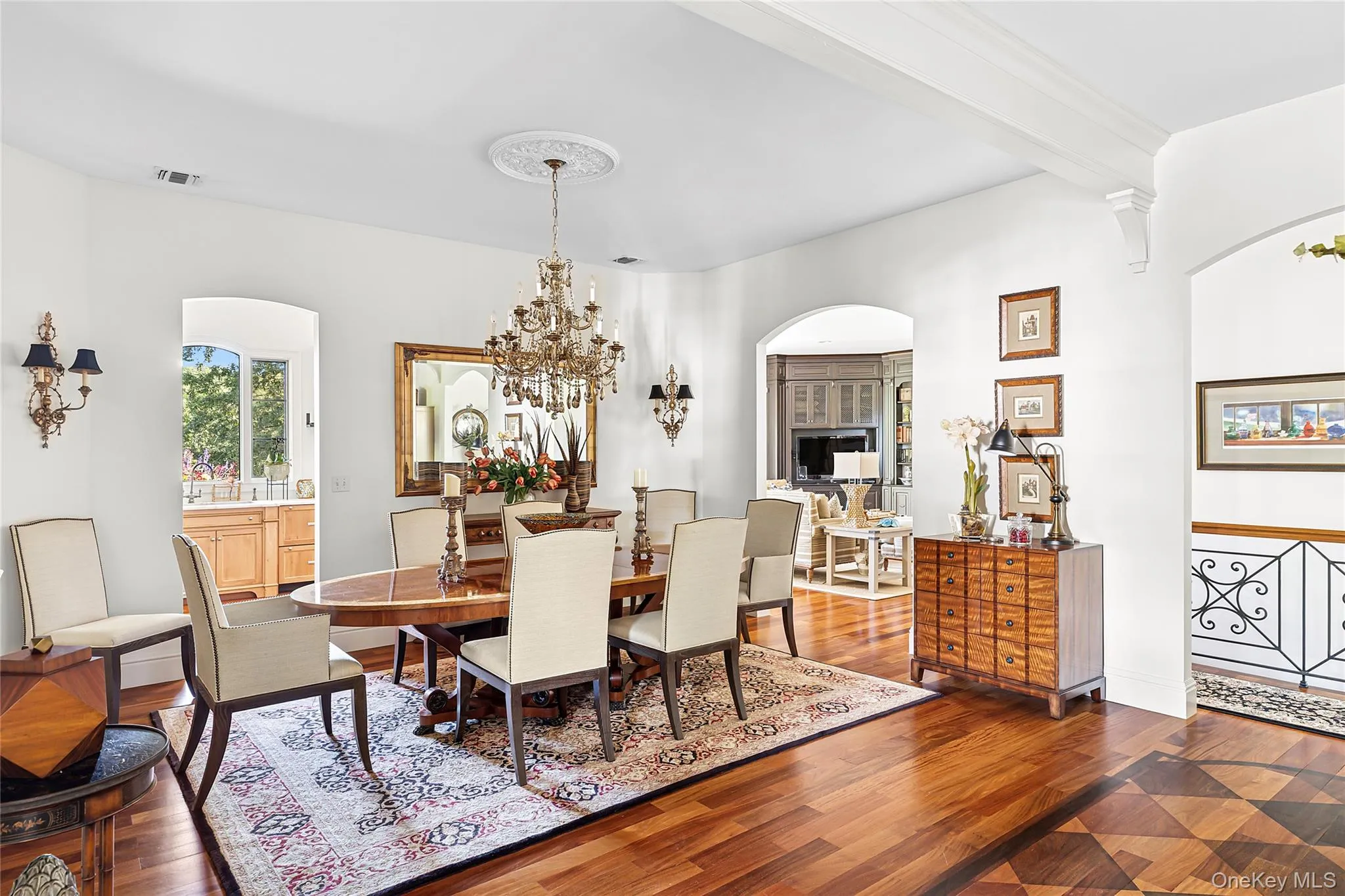 Dining room featuring dark wood-type flooring, a chandelier, beamed ceiling, and arched walkways Dining room featuring dark wood-type flooring, a chandelier, beamed ceiling, and arched walkways