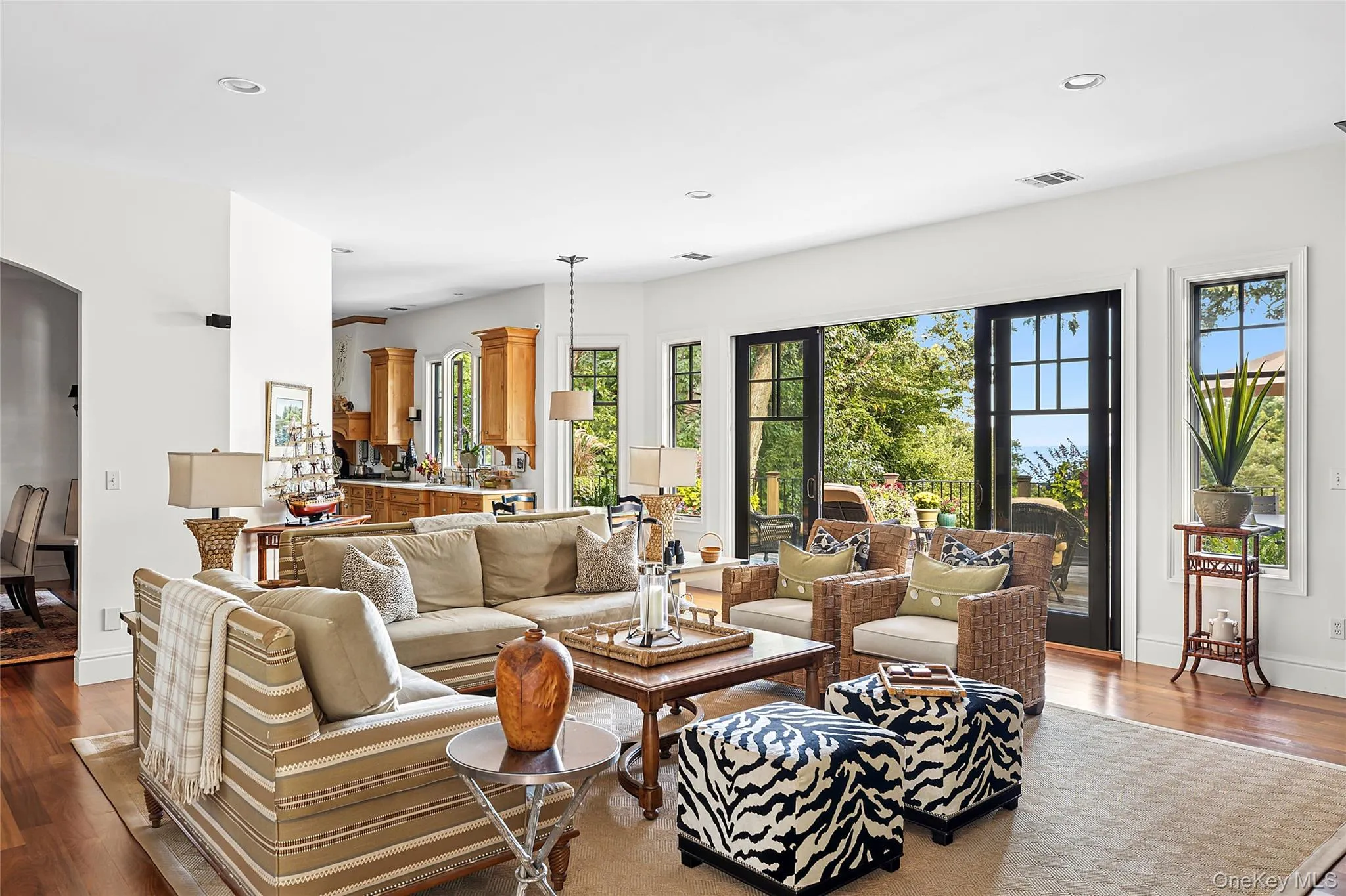 Living room featuring wood finished floors, recessed lighting, and arched walkways Living room featuring wood finished floors, recessed lighting, and arched walkways