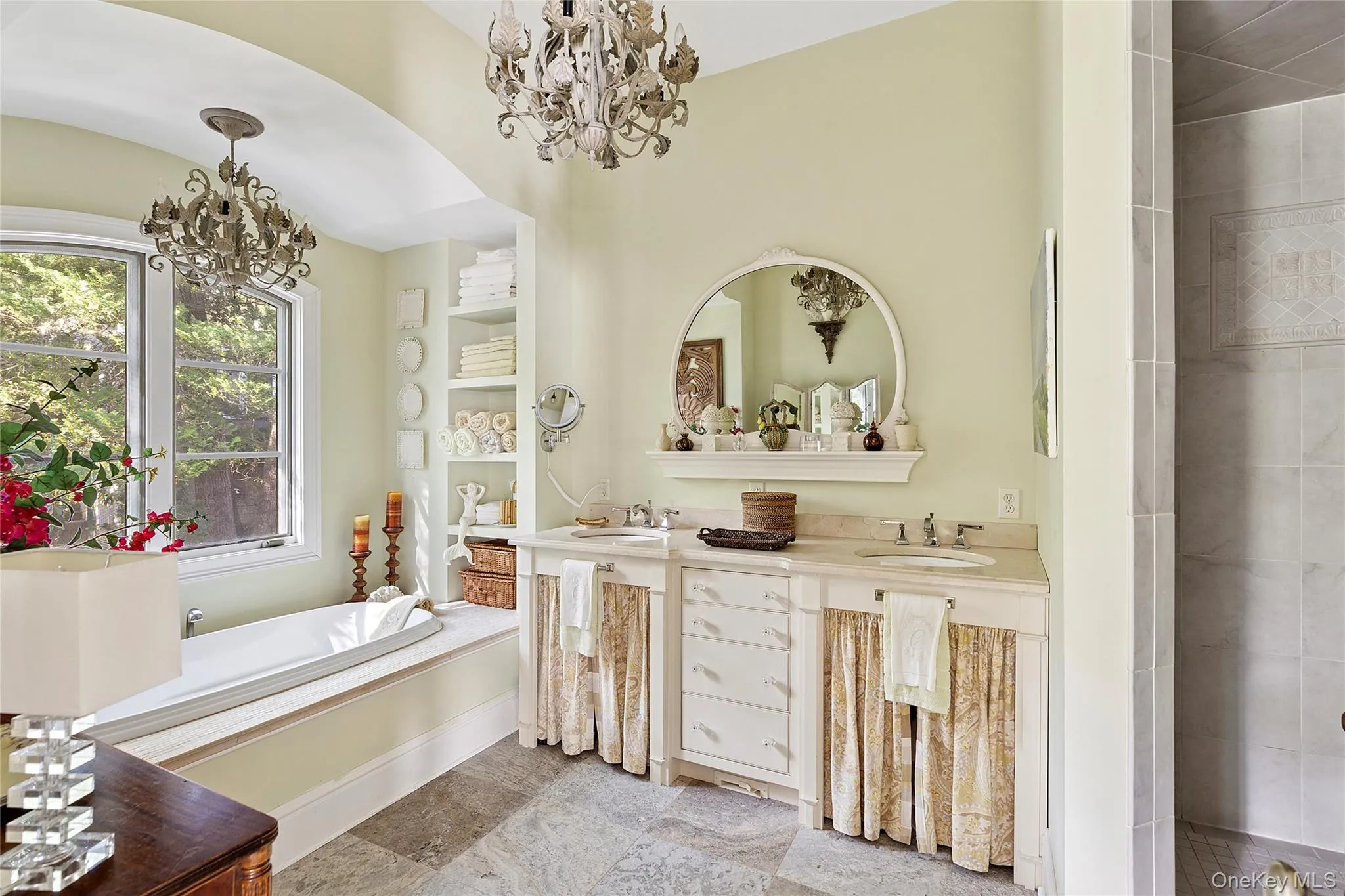 Bathroom with a chandelier, double vanity, a garden tub, and a tile shower Bathroom with a chandelier, double vanity, a garden tub, and a tile shower