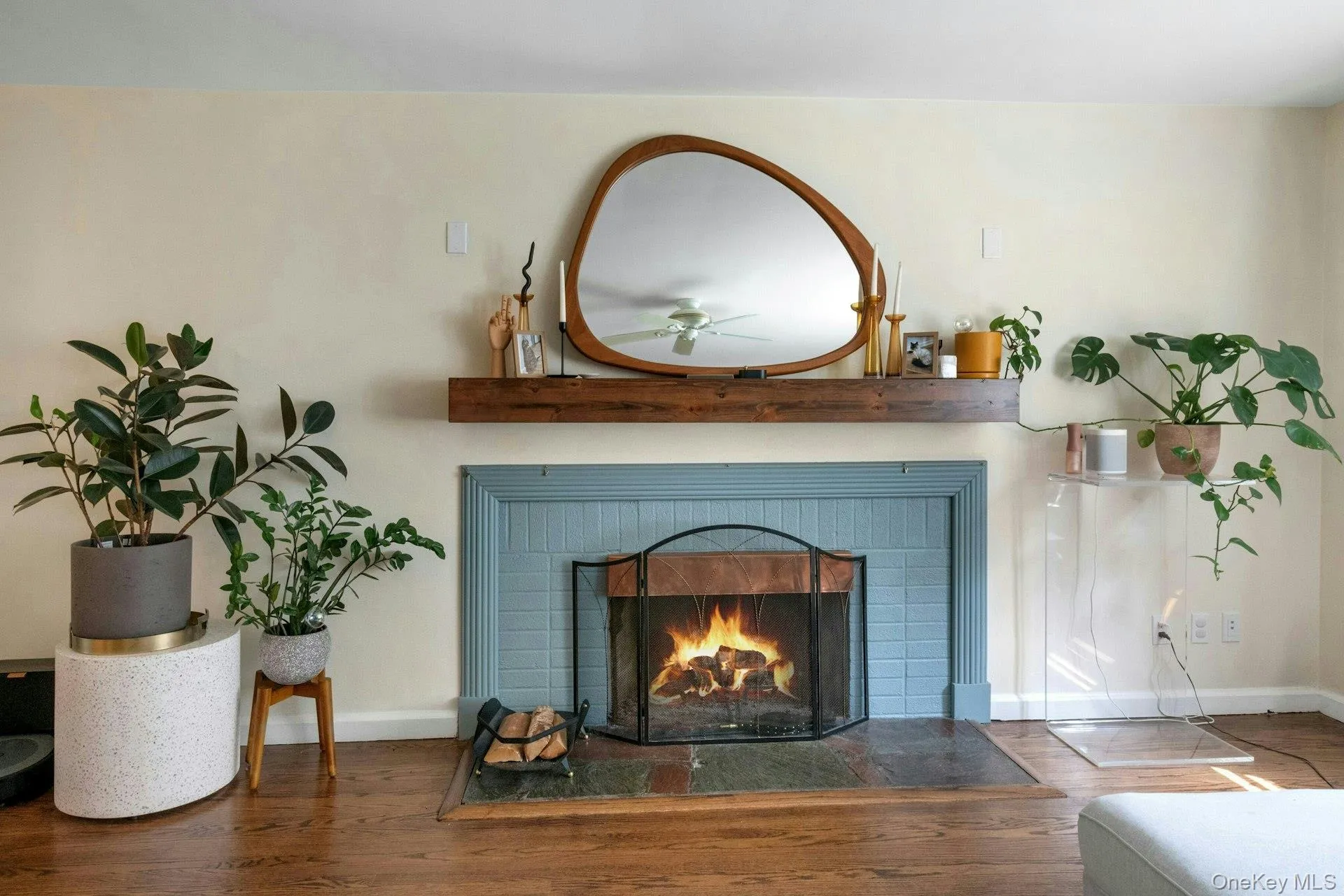 Detailed view of a brick fireplace, wood finished floors, and a ceiling fan Detailed view of a brick fireplace, wood finished floors, and a ceiling fan