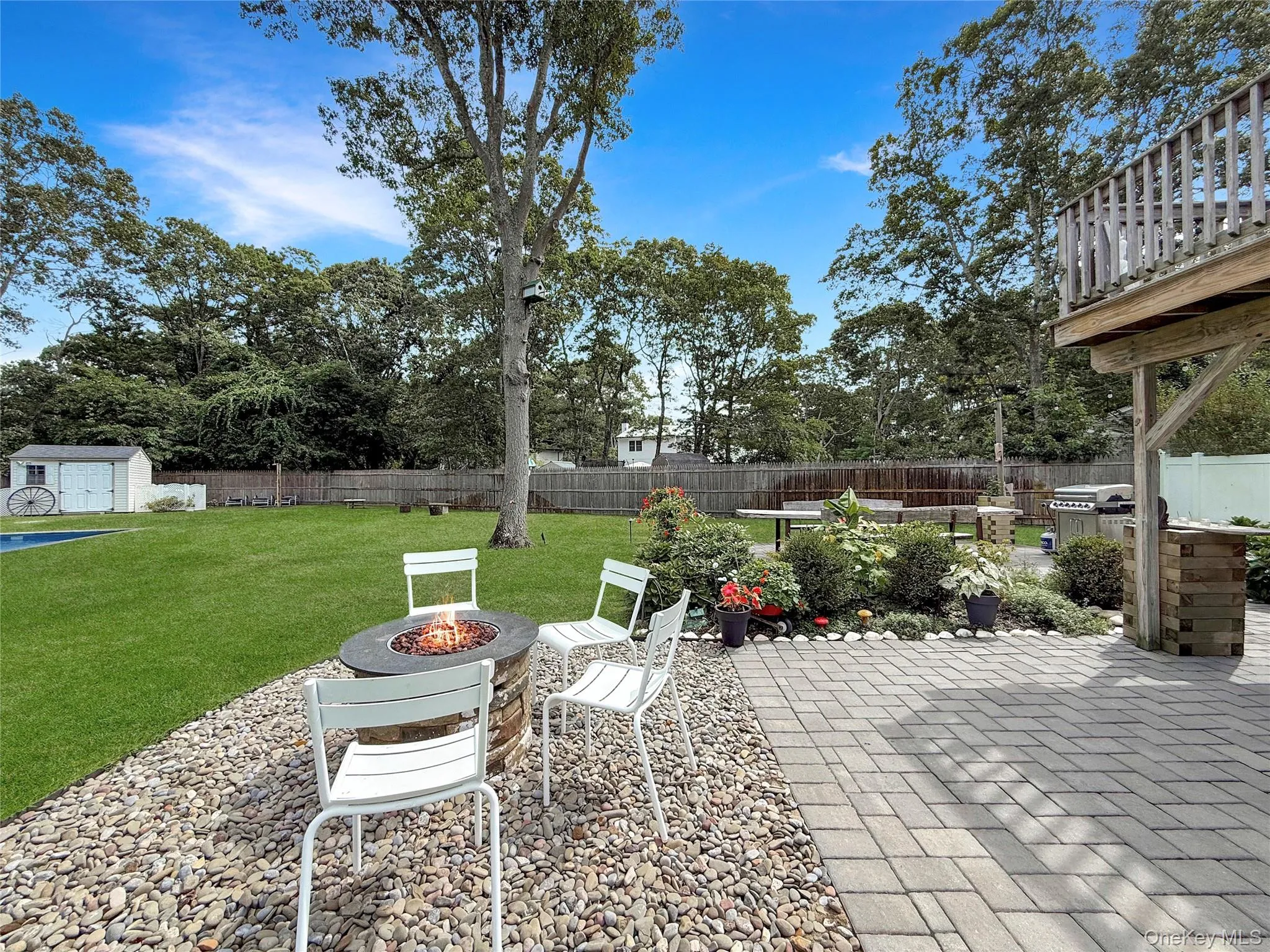 Fenced backyard with a fire pit, a patio, and a shed Fenced backyard with a fire pit, a patio, and a shed