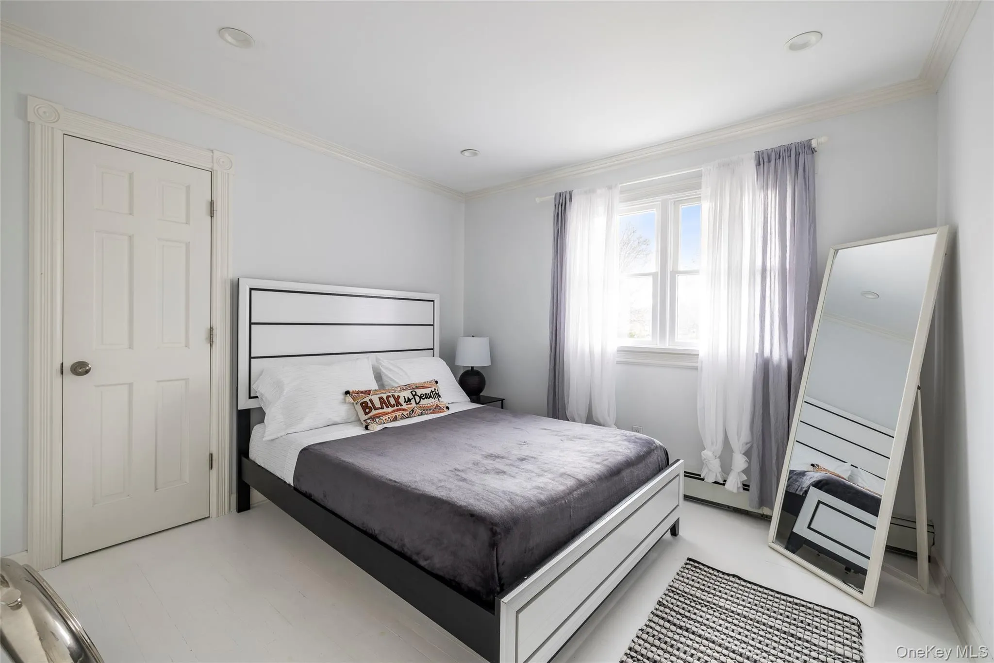 Bedroom with crown molding and baseboard heating Bedroom with crown molding and baseboard heating