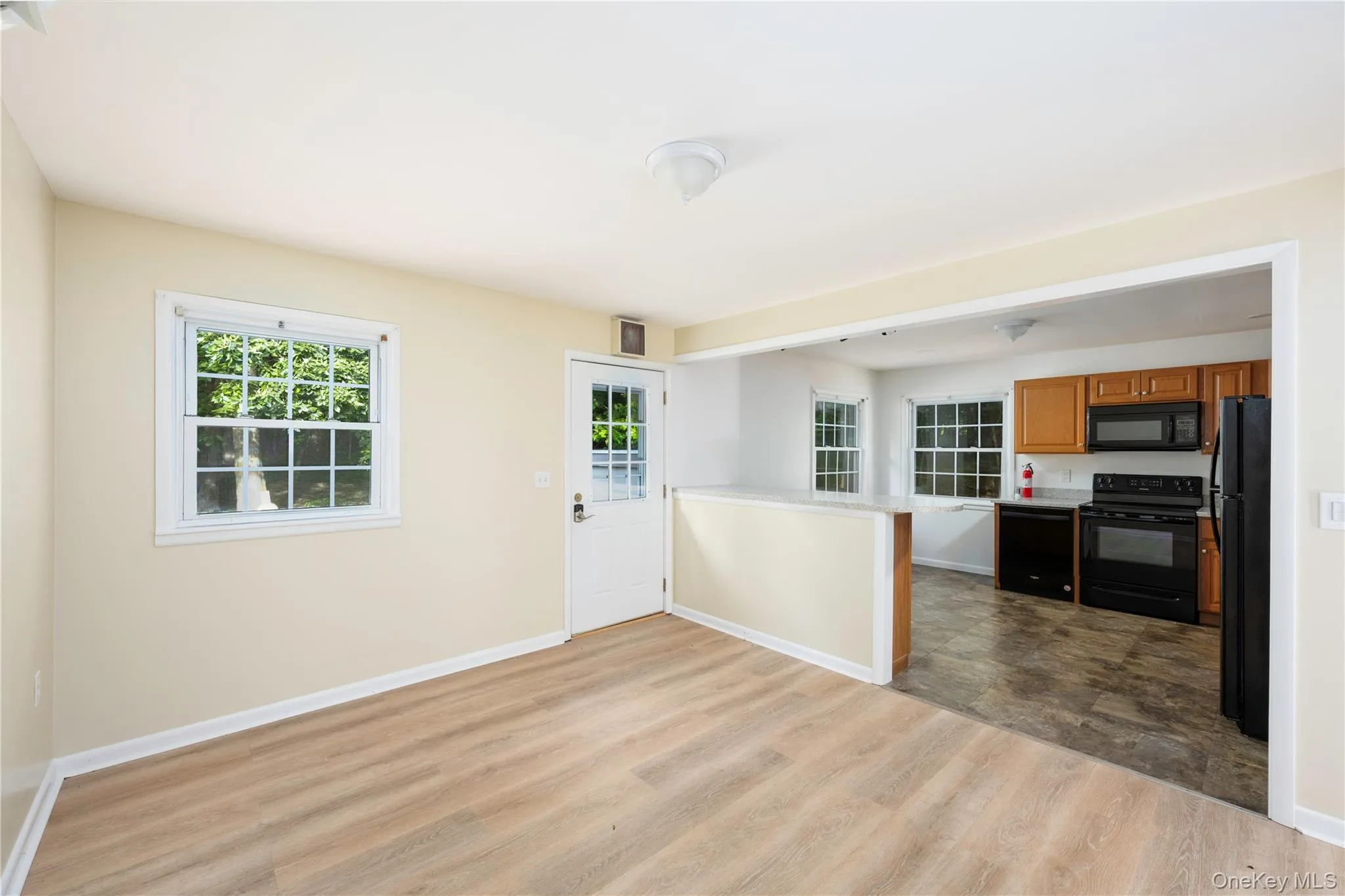 Unfurnished living room featuring baseboards and dark wood-style floors Unfurnished living room featuring baseboards and dark wood-style floors