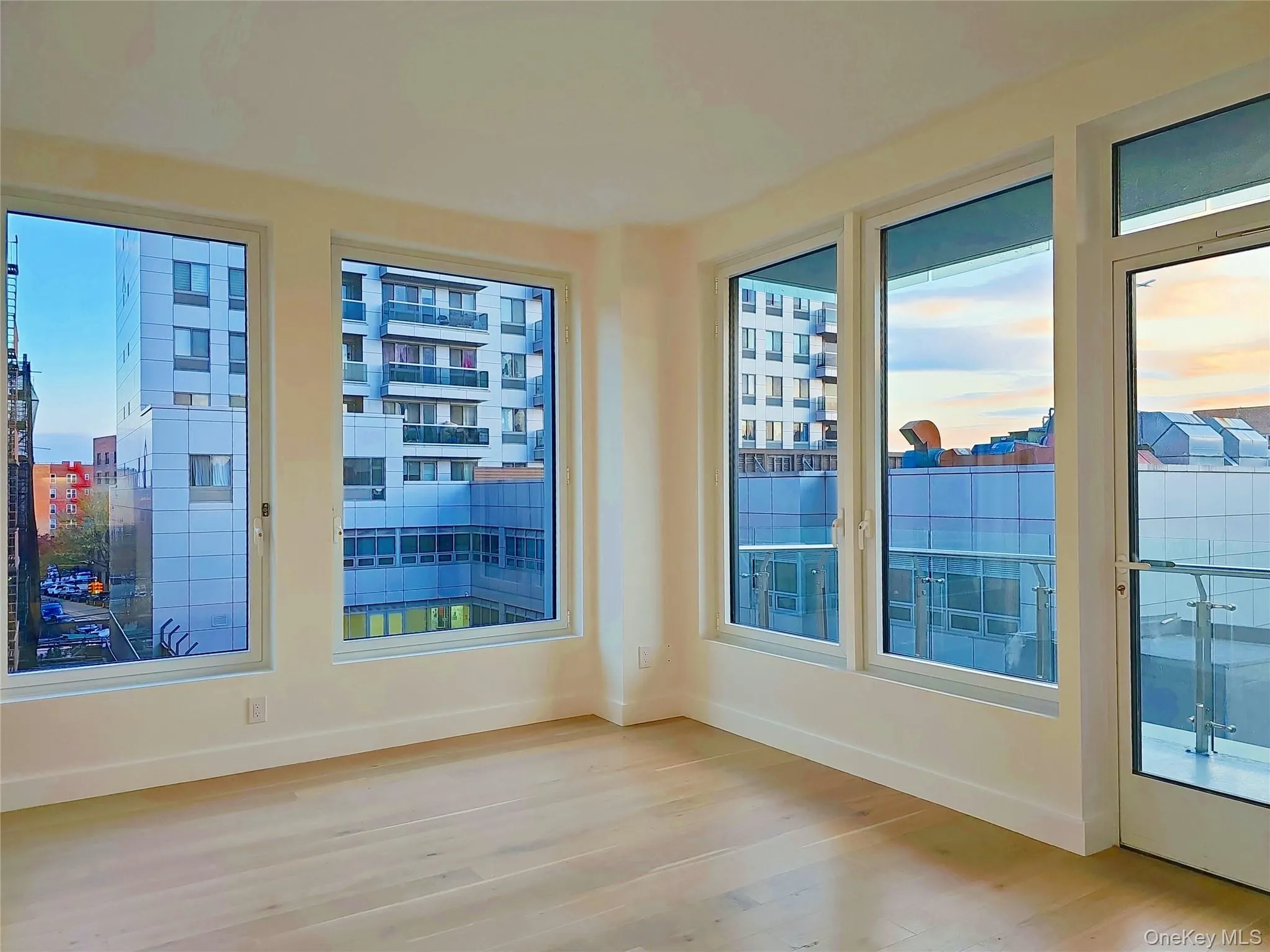 Unfurnished room with wood finished floors and plenty of natural light Unfurnished room with wood finished floors and plenty of natural light