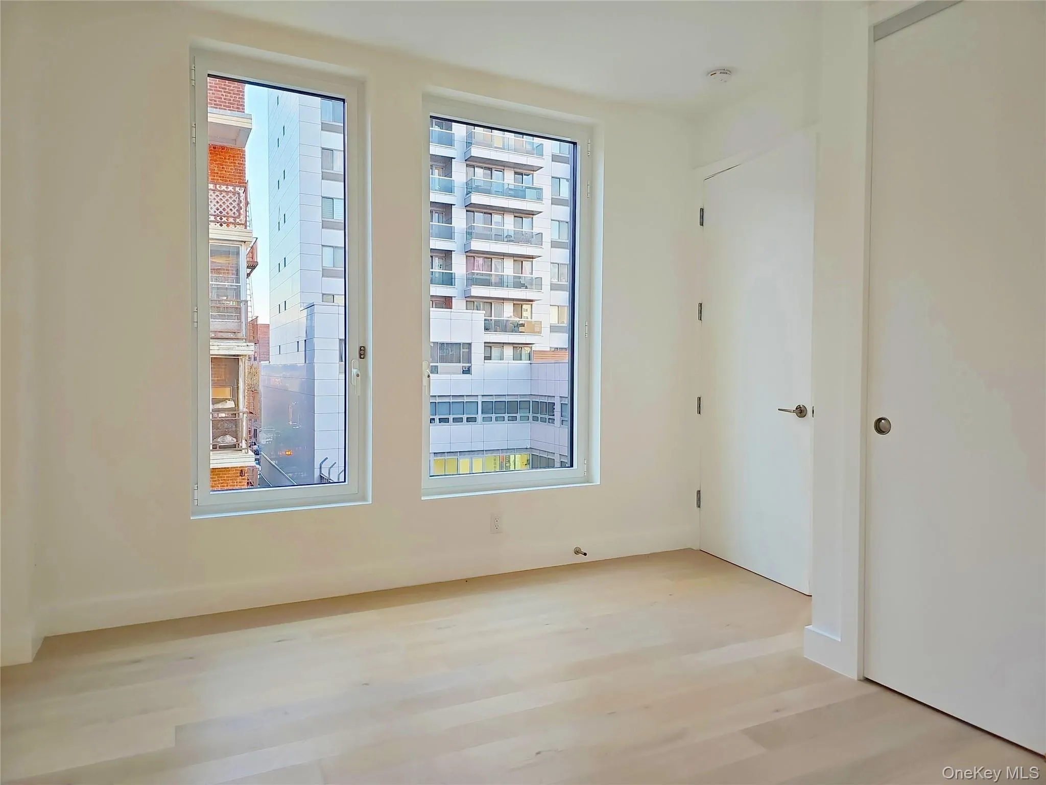 Spare room with wood finished floors and a smoke detector Spare room with wood finished floors and a smoke detector