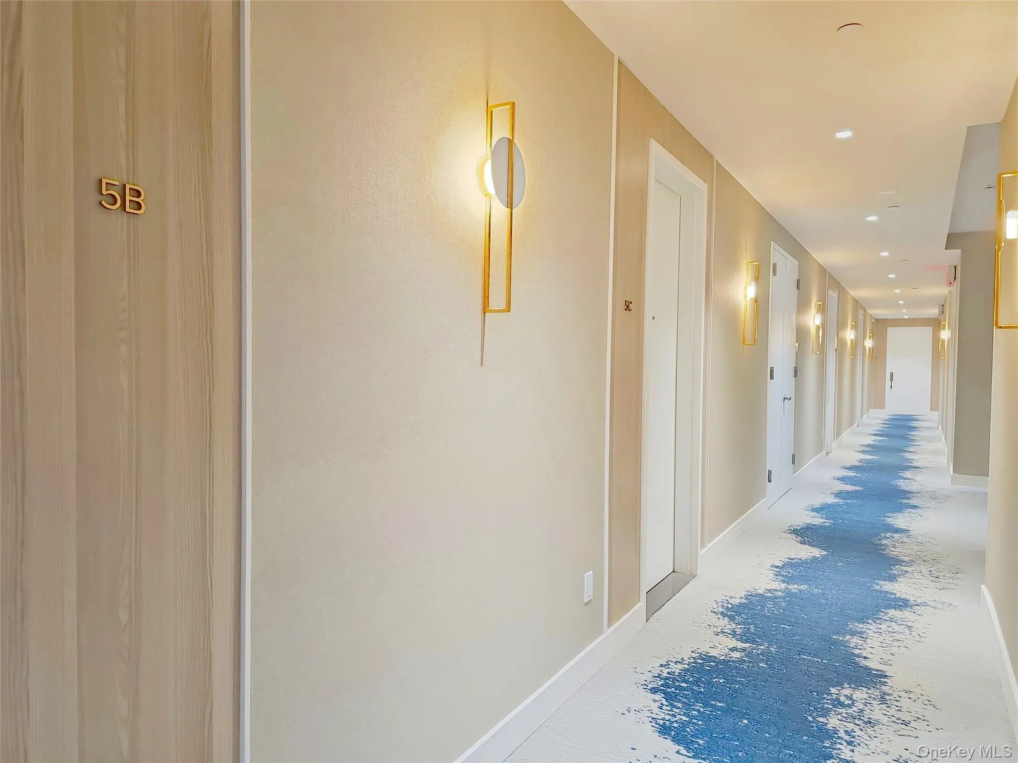 Hall featuring unfinished concrete floors and recessed lighting Hall featuring unfinished concrete floors and recessed lighting