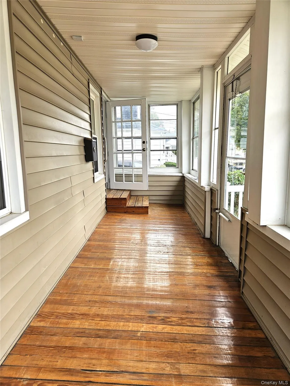 Unfurnished sunroom with wood-type flooring, wood walls, and wood ceiling Unfurnished sunroom with wood-type flooring, wood walls, and wood ceiling