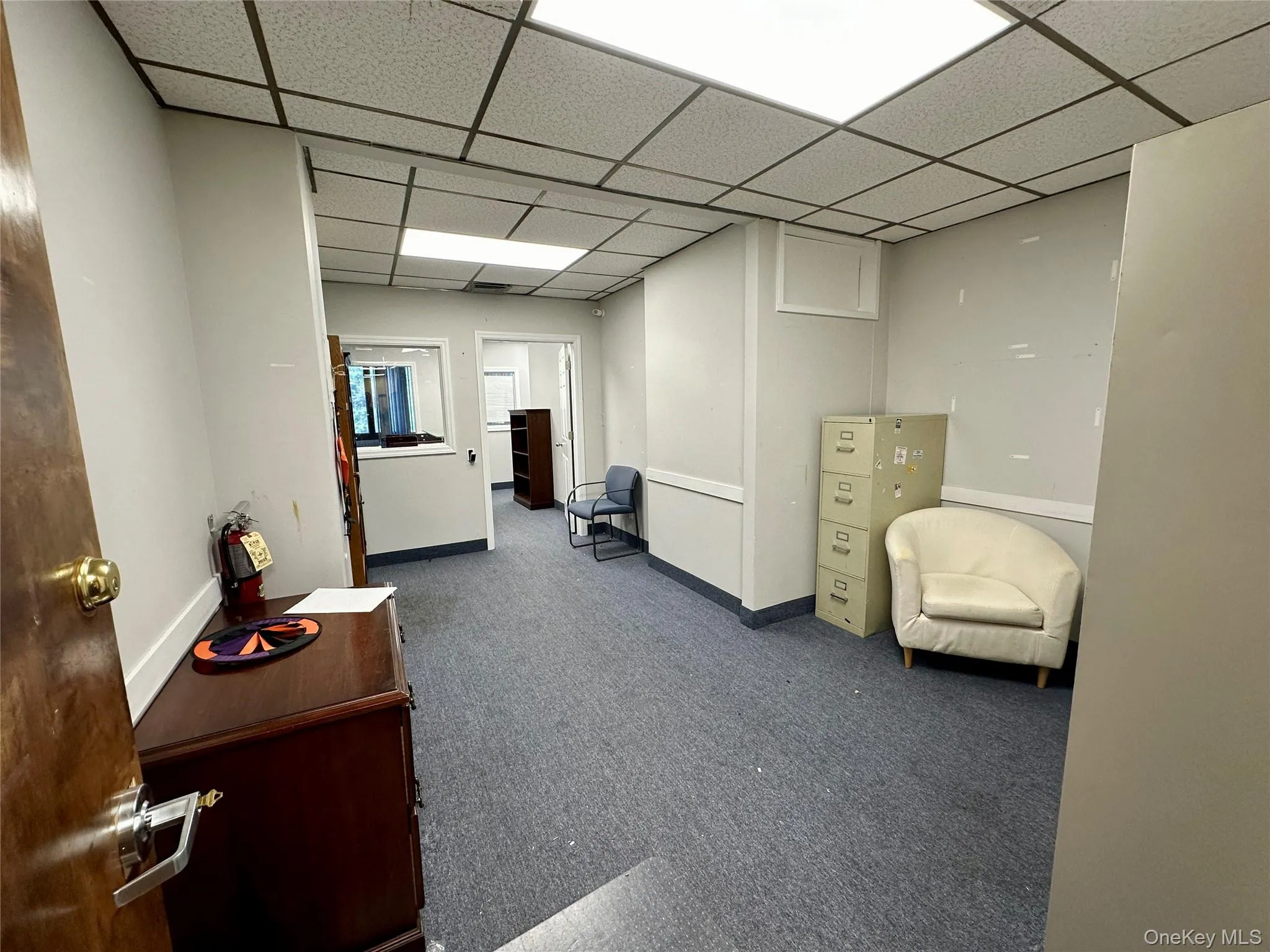 Hall with carpet flooring and a drop ceiling Hall with carpet flooring and a drop ceiling