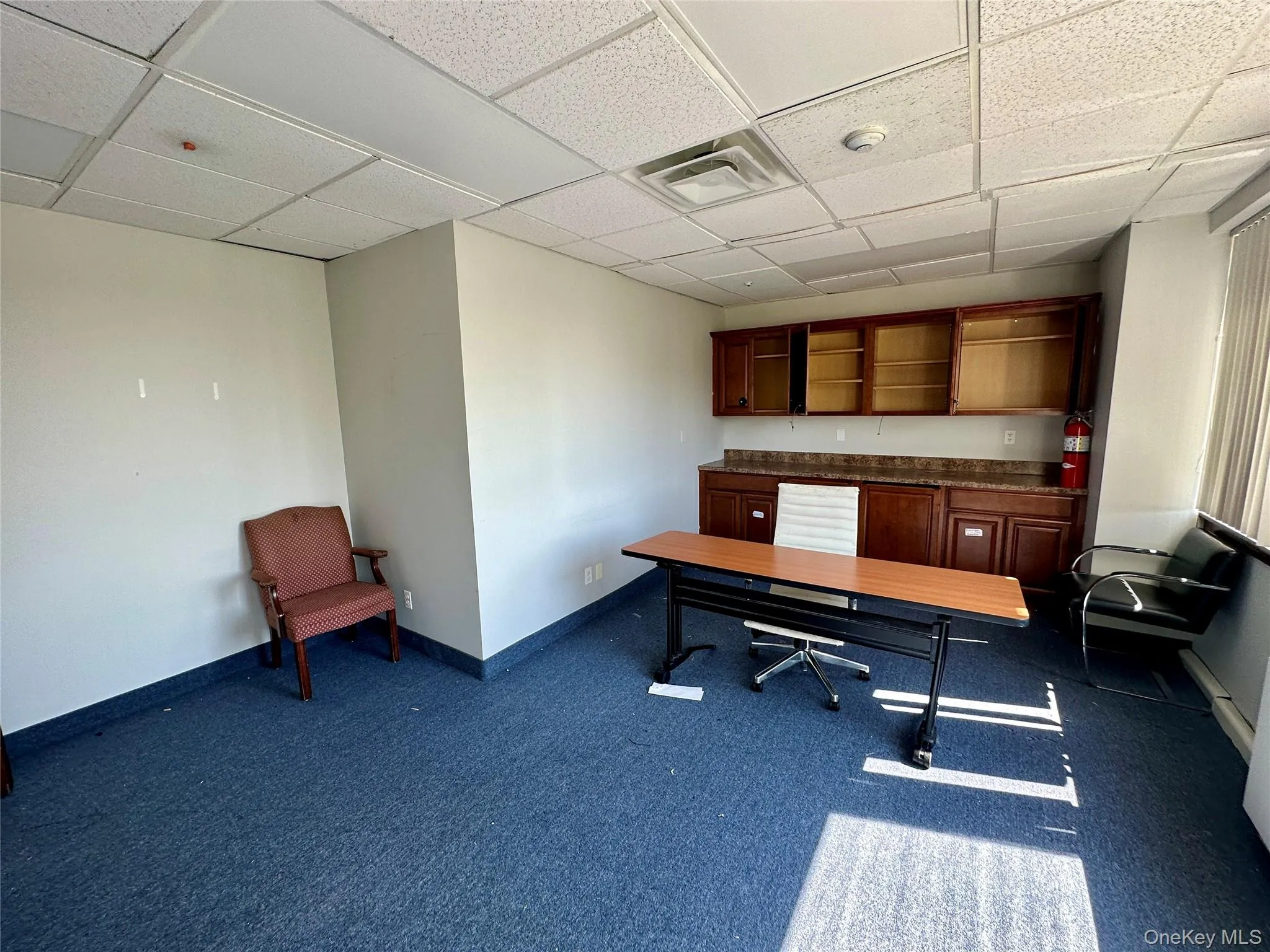 Unfurnished office featuring a drop ceiling and dark carpet Unfurnished office featuring a drop ceiling and dark carpet