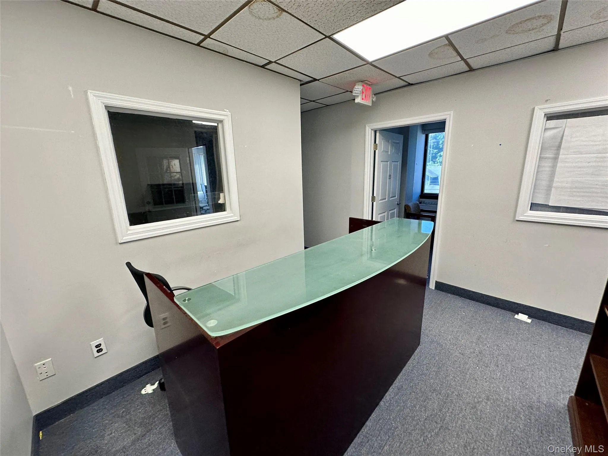 Unfurnished office with dark colored carpet and a paneled ceiling Unfurnished office with dark colored carpet and a paneled ceiling
