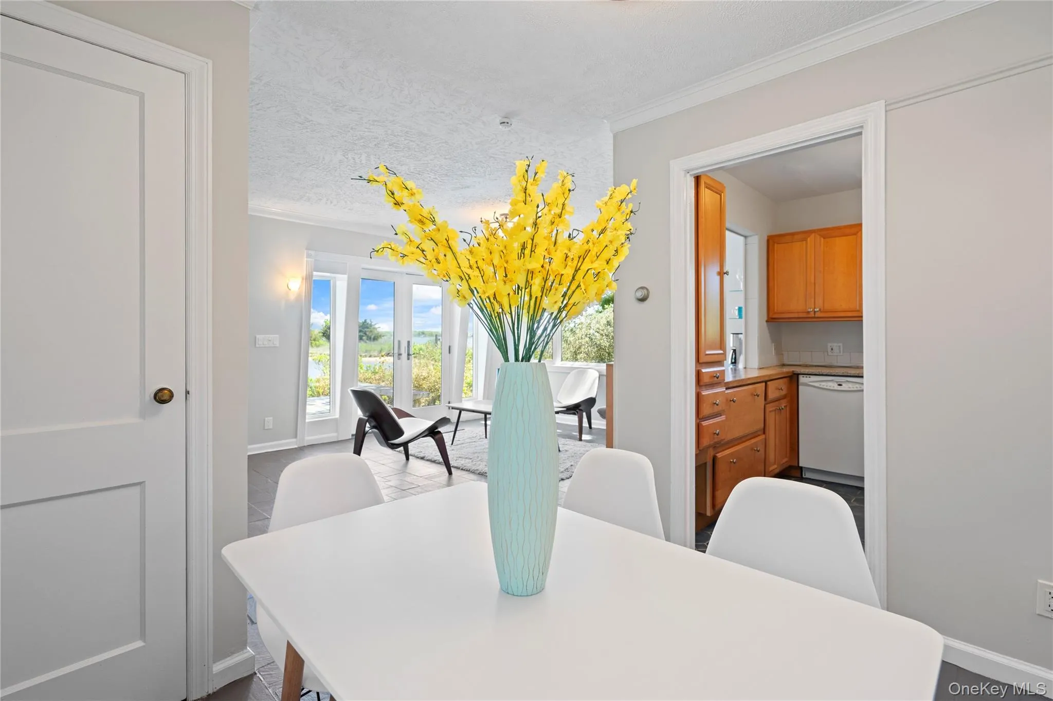 Dining area featuring french doors, crown molding, and a textured ceiling Dining area featuring french doors, crown molding, and a textured ceiling