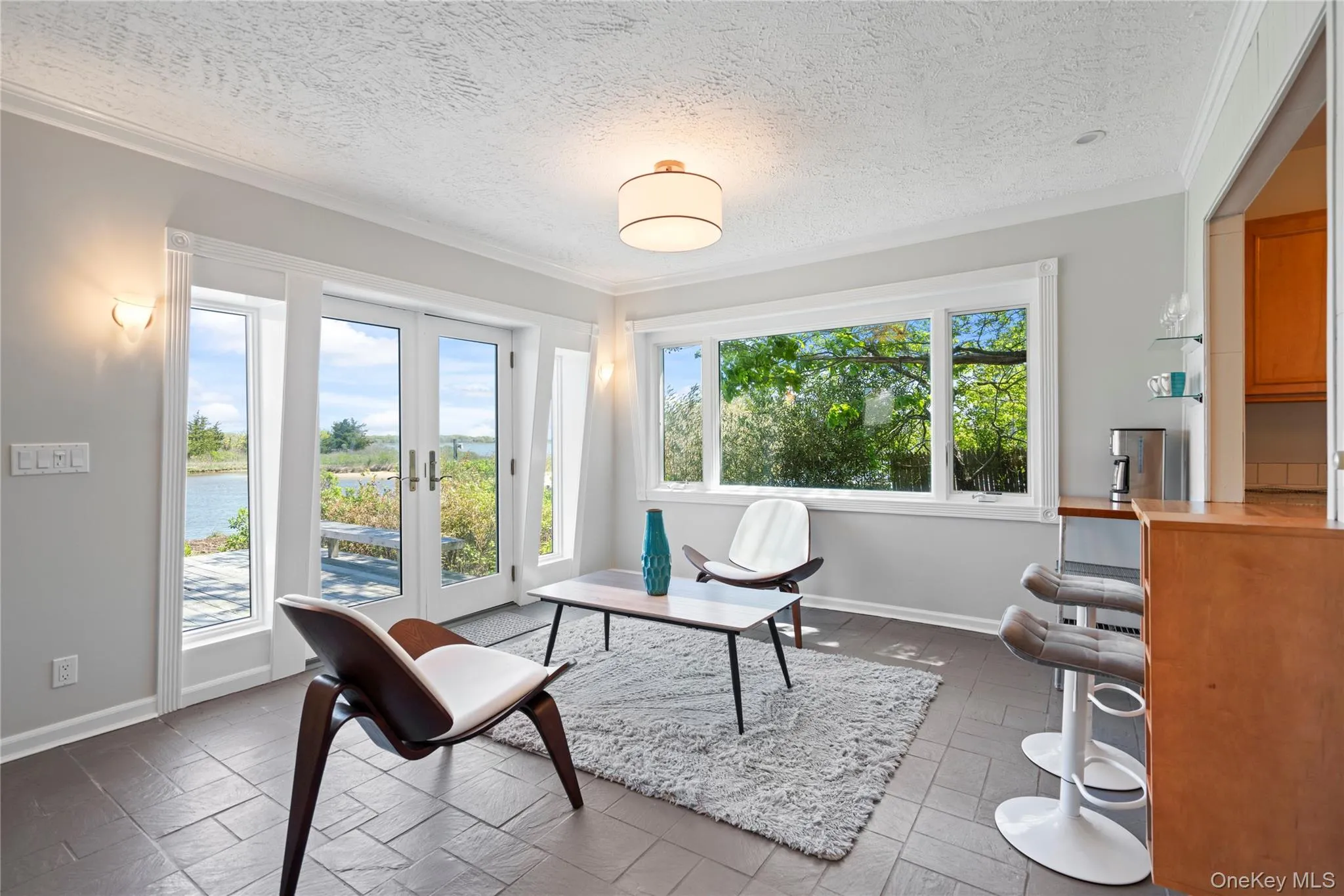 Office featuring a textured ceiling, french doors, and a water view Office featuring a textured ceiling, french doors, and a water view