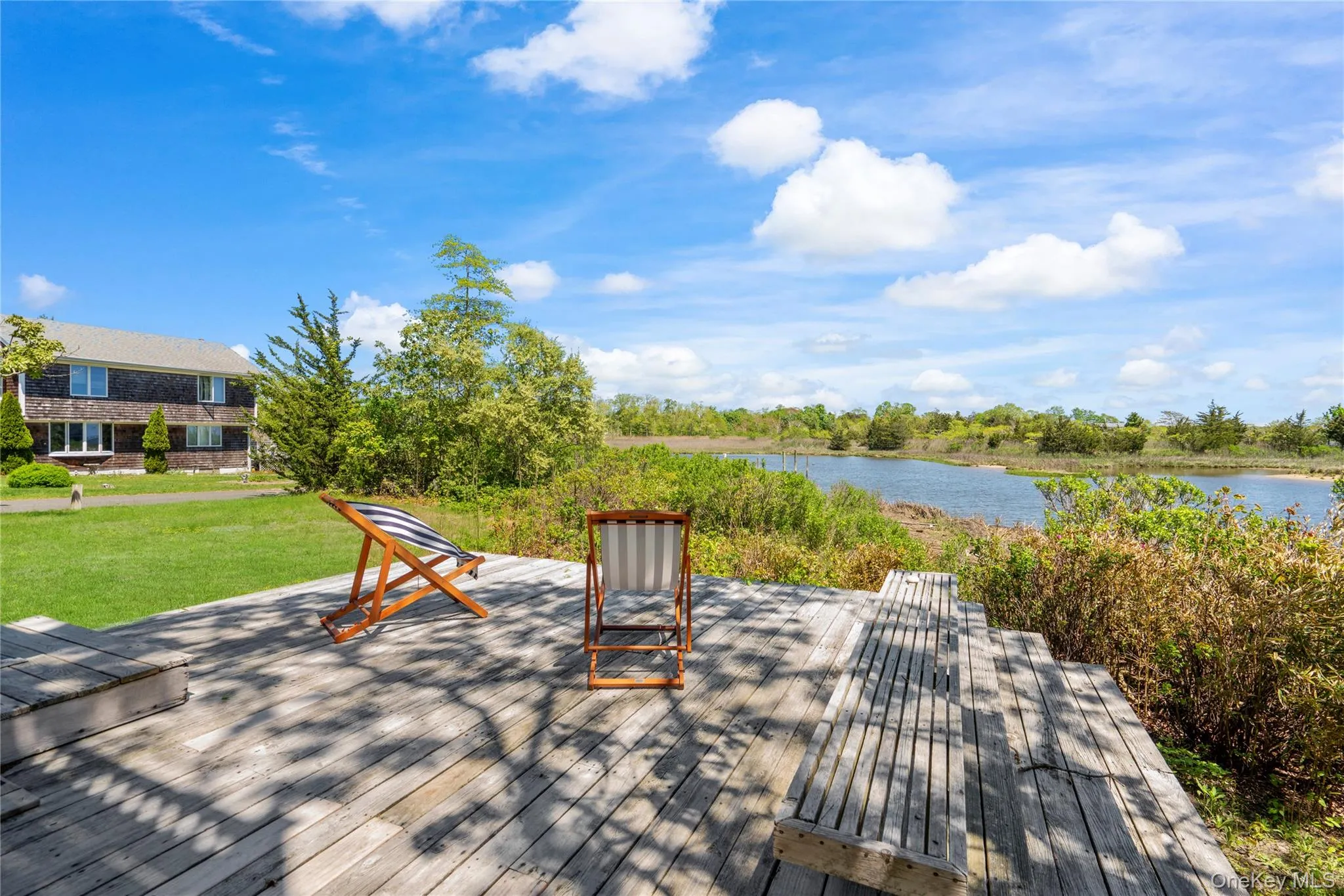 Wooden deck with a water view and a yard Wooden deck with a water view and a yard