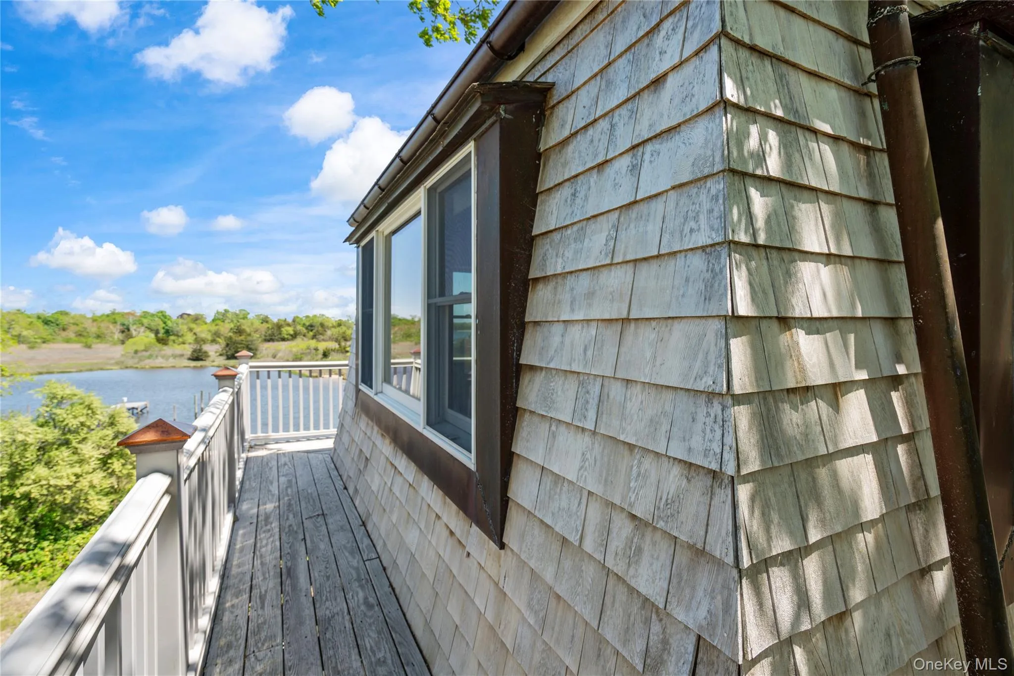 View of side of home featuring a water view and a balcony View of side of home featuring a water view and a balcony