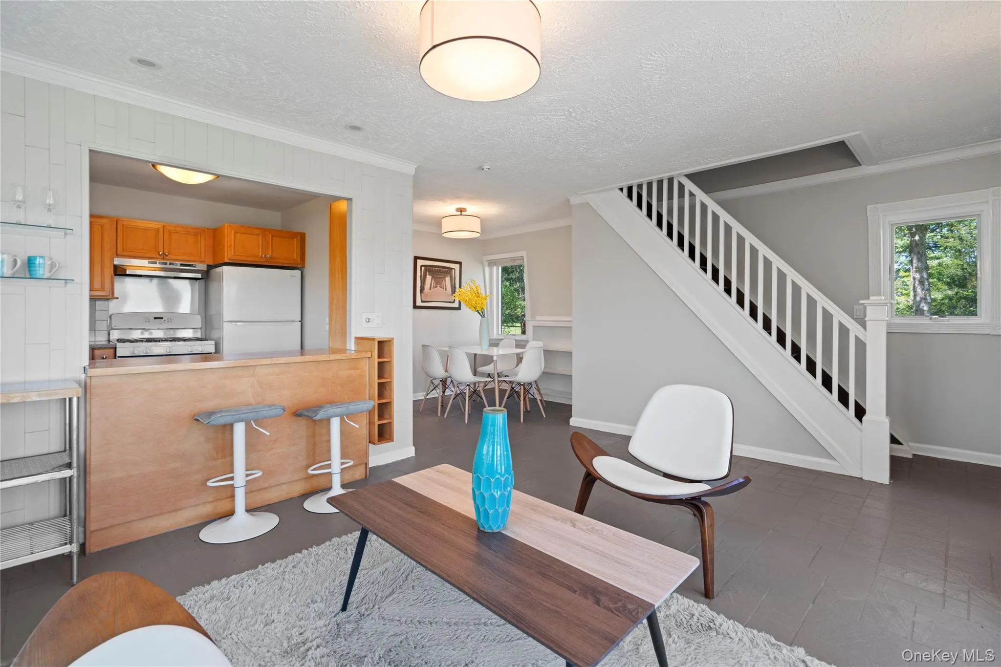 Living room featuring crown molding, a textured ceiling, and stairway Living room featuring crown molding, a textured ceiling, and stairway