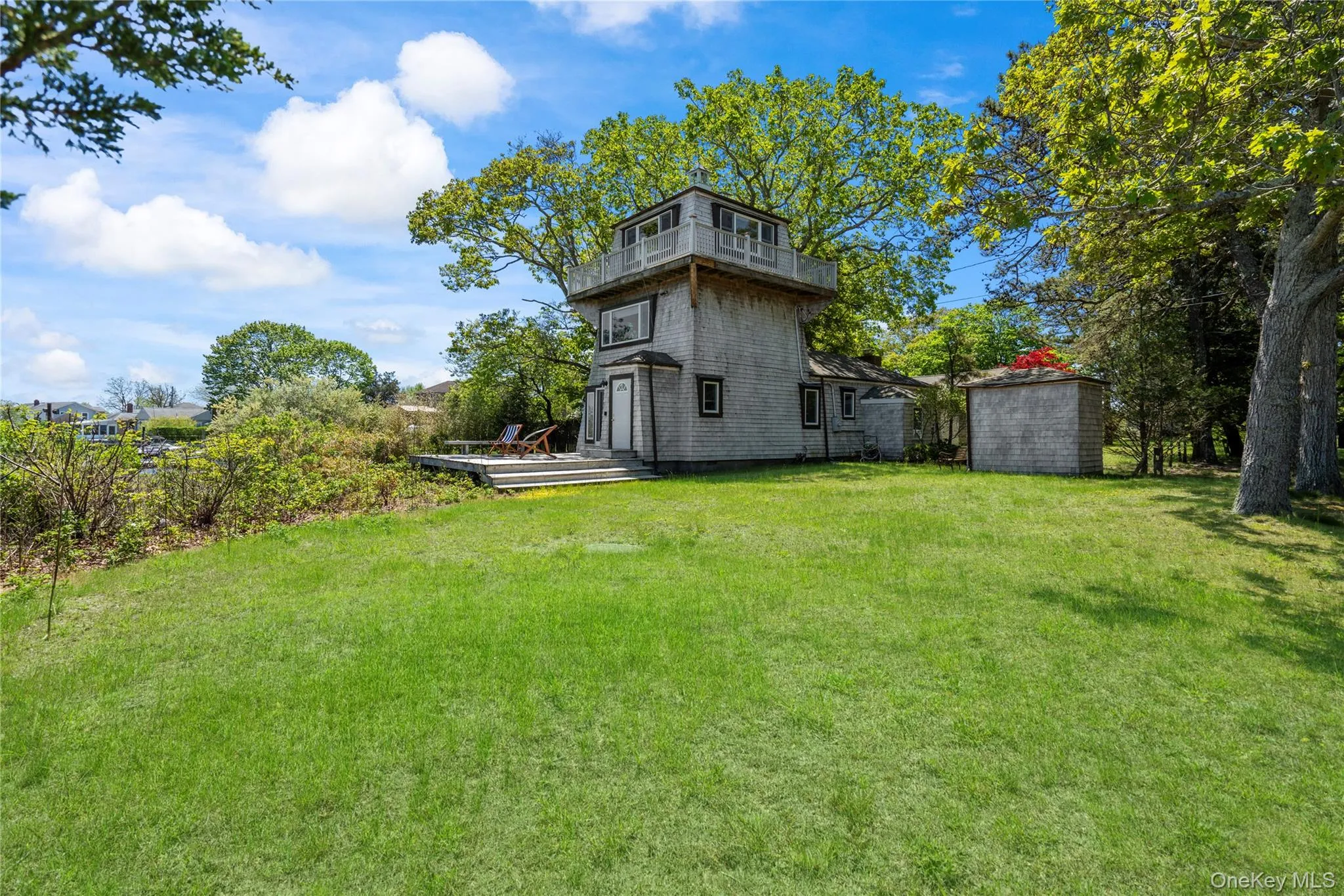 View of grassy yard featuring a deck and a shed View of grassy yard featuring a deck and a shed